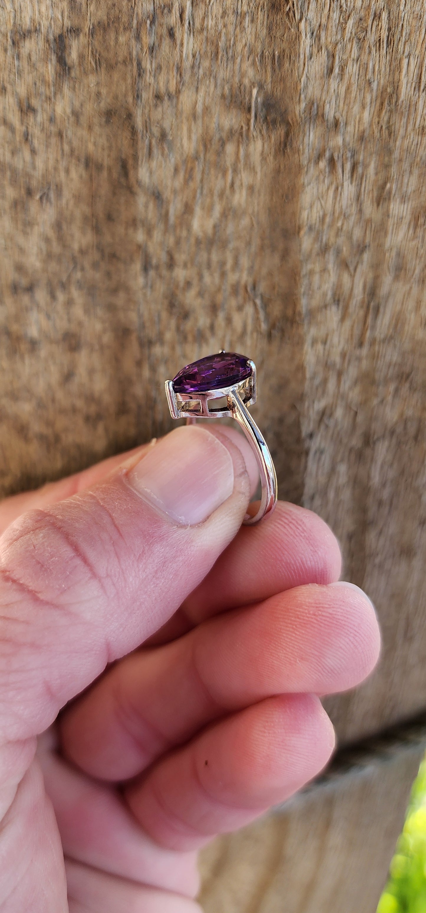 Sterling Silver Solitaire ring claw set with a Pear cut Amethyst Gemstone in a open Gallery basket.