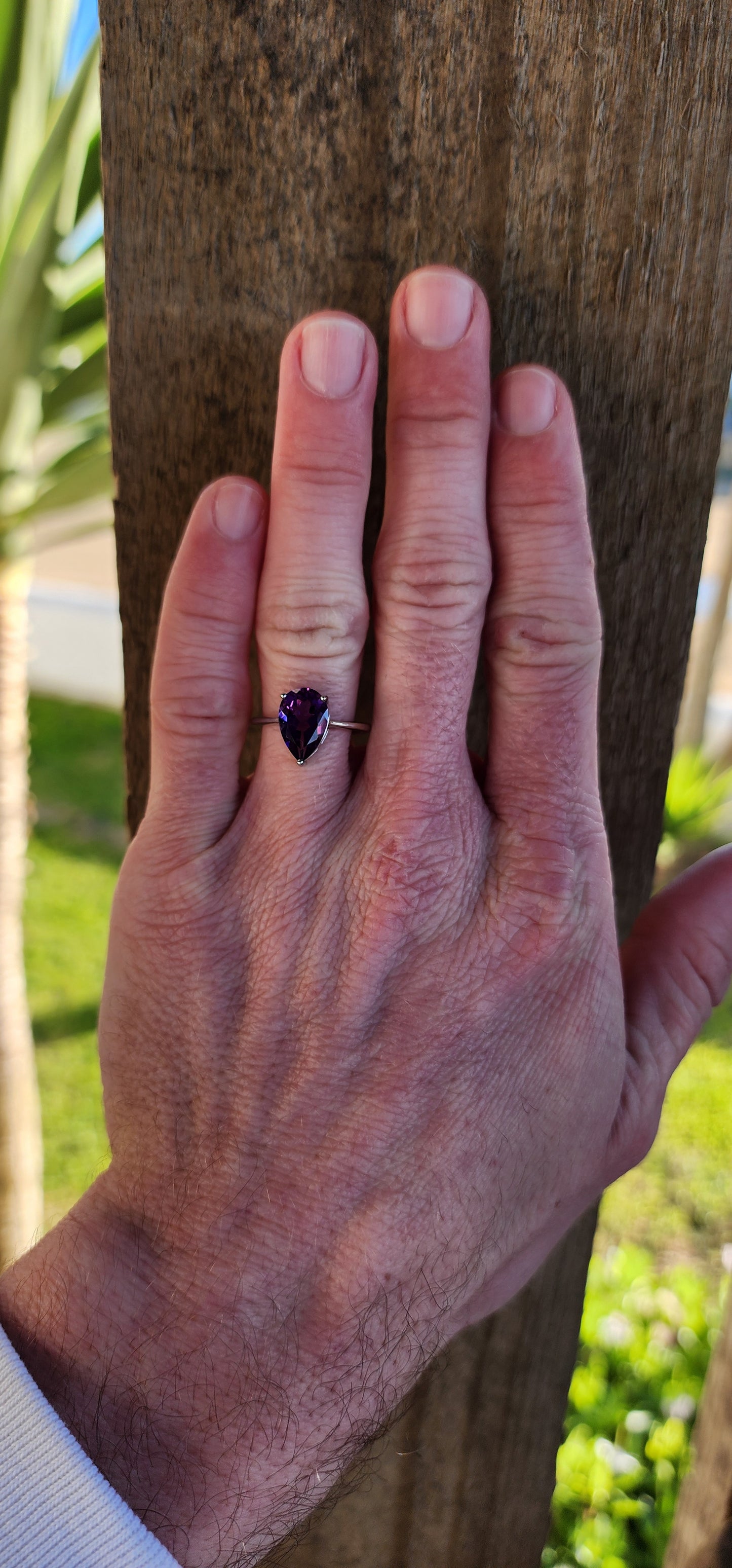 Sterling Silver Solitaire ring claw set with a Pear cut Amethyst Gemstone in a open Gallery basket.