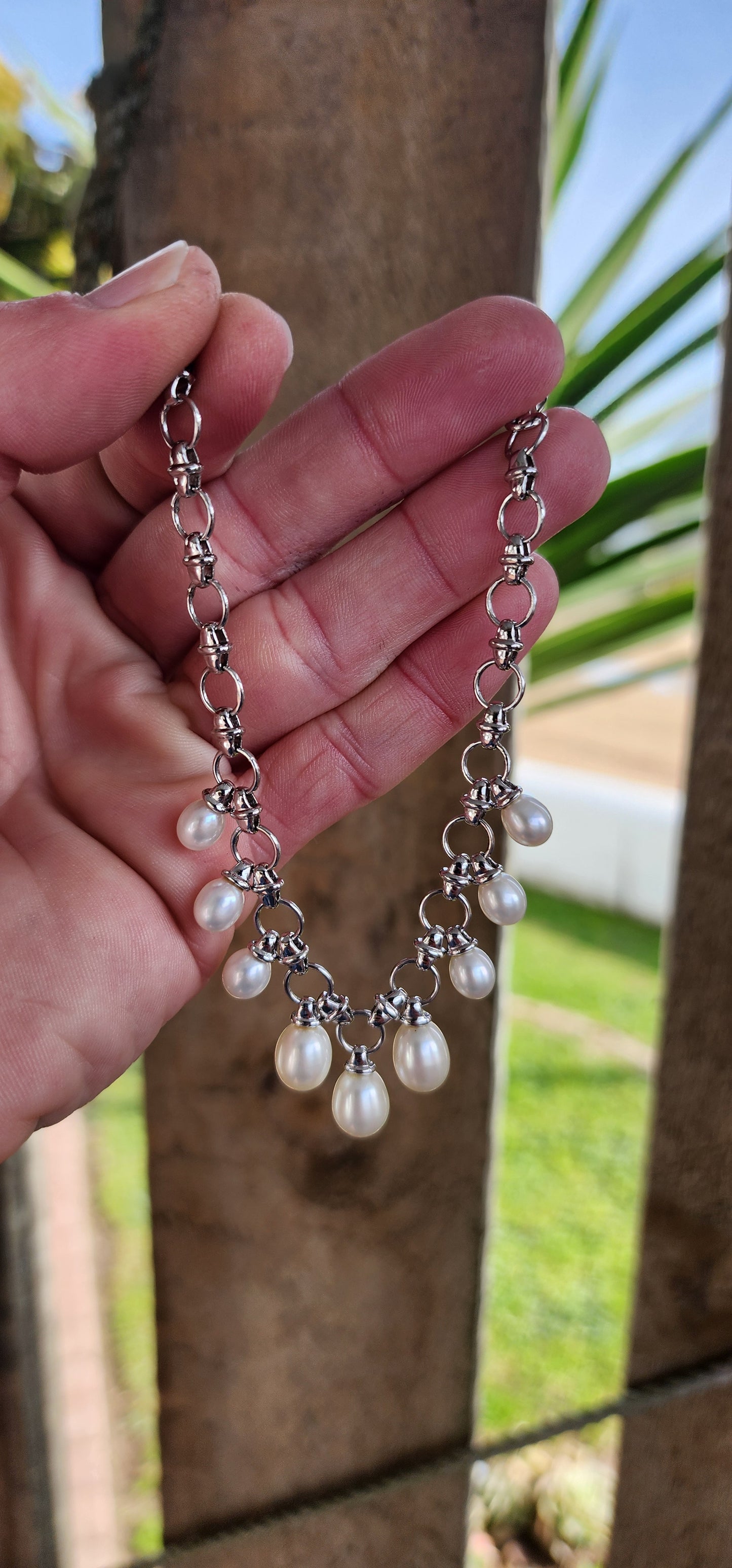 Classical beauty ! Sterling Silver fancy link bracelet adorned with 9x Teardrop Freshwater Pearl drop charms in graduated sizes.