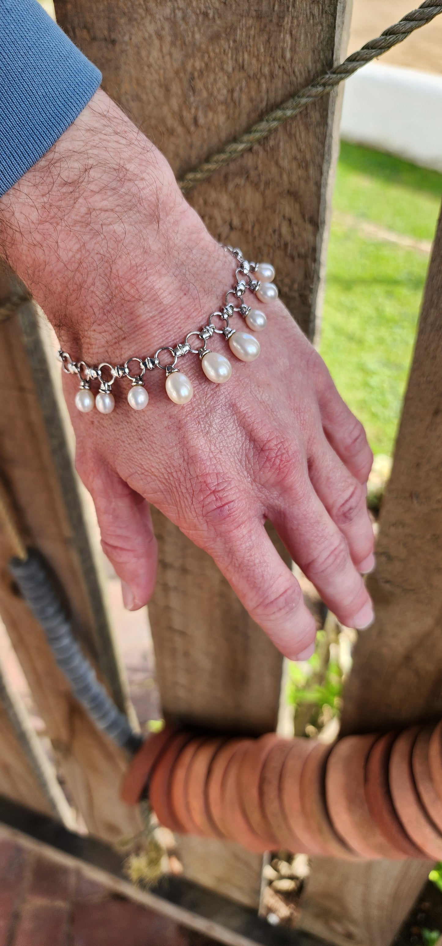 Classical beauty ! Sterling Silver fancy link bracelet adorned with 9x Teardrop Freshwater Pearl drop charms in graduated sizes.