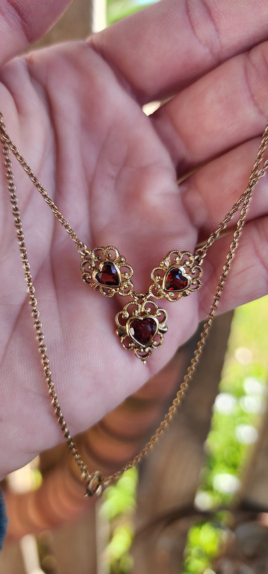 The most beautiful and petite necklace designed in a glorious Antique style.
Crafted in Sterling Silver with 18ct Yellow Gold plating, the necklace features triple jointed Heart pendants ,each pendant bezel/tube set with a fancy Heart cut Garnet.