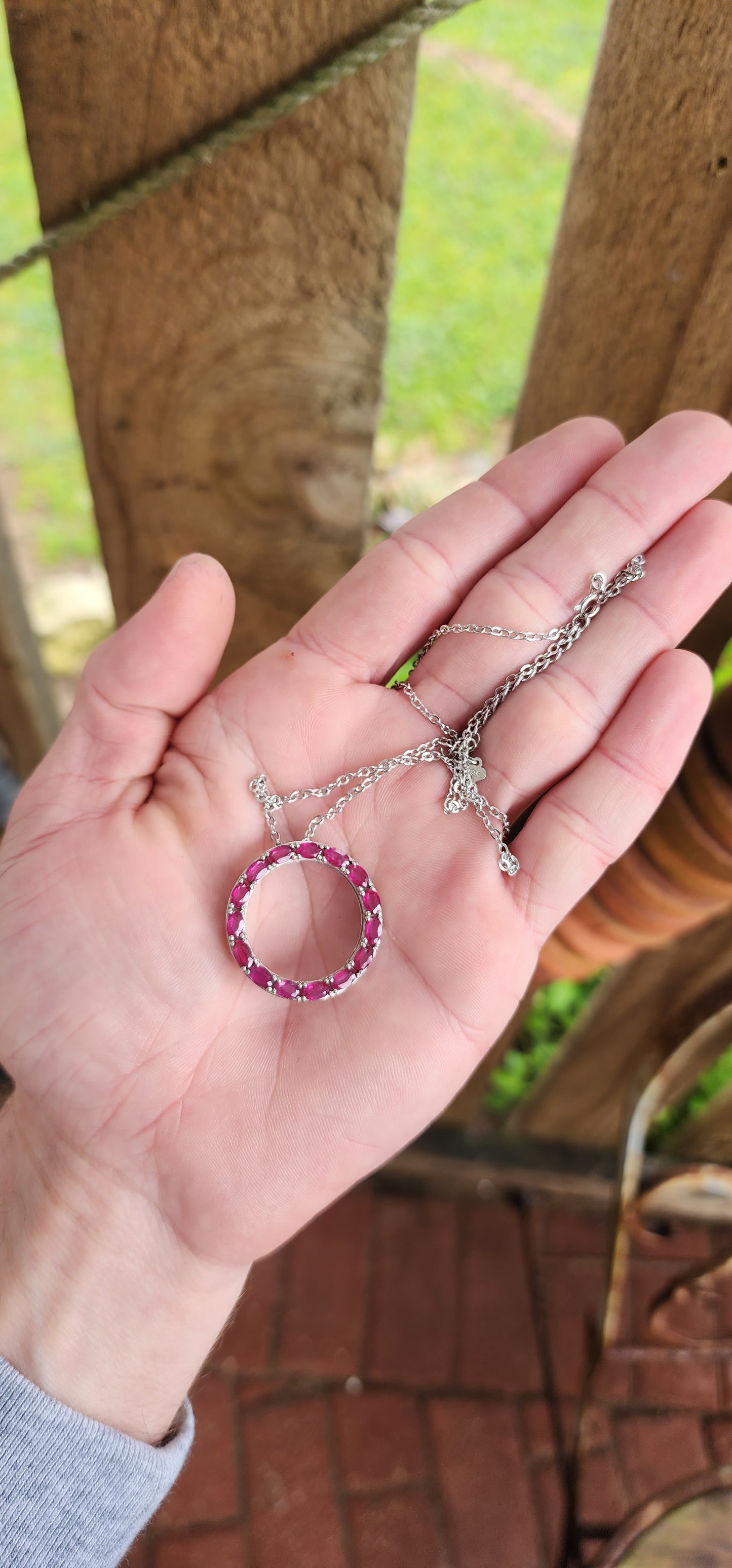 Beautiful and elegant Circle of life pendant on chain.A halo of Natural Oval cut Ruby Gemstones in prong settings,finely arranged in an Sterling Silver open Circle design.