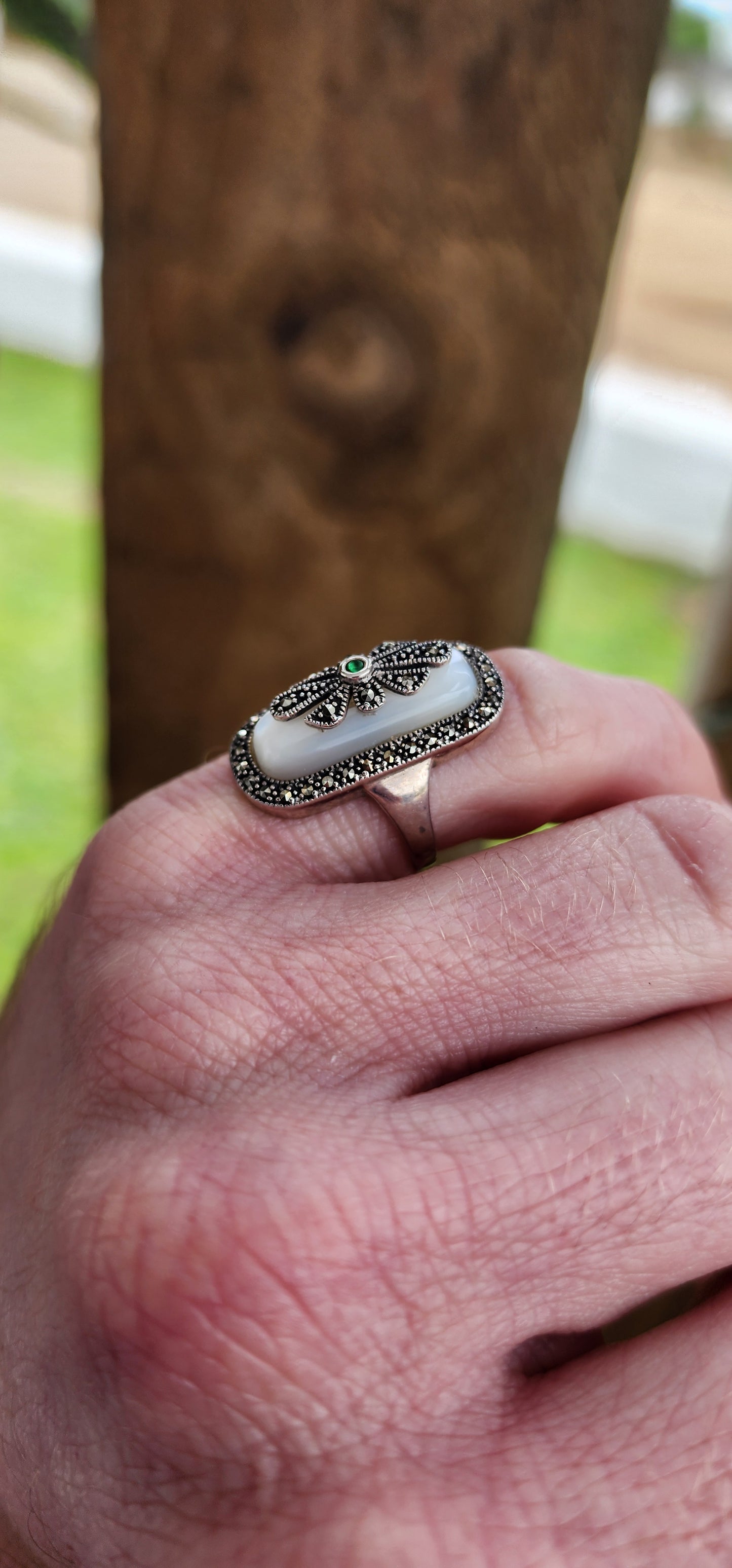 Art Deco style Sterling silver ring bezel/tube set with a Rectangular shaped Mother of Pearl Cabochon, framed in a sparkly Marcasite border.