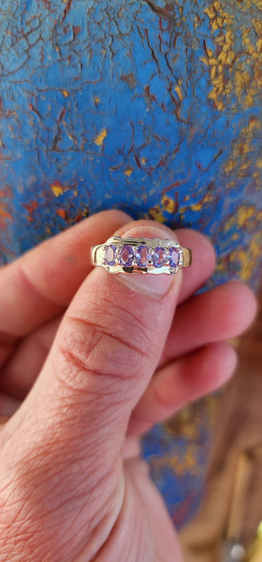 This exquisite Half Eternity style band featuring Natural Tanzanite Gemstones.