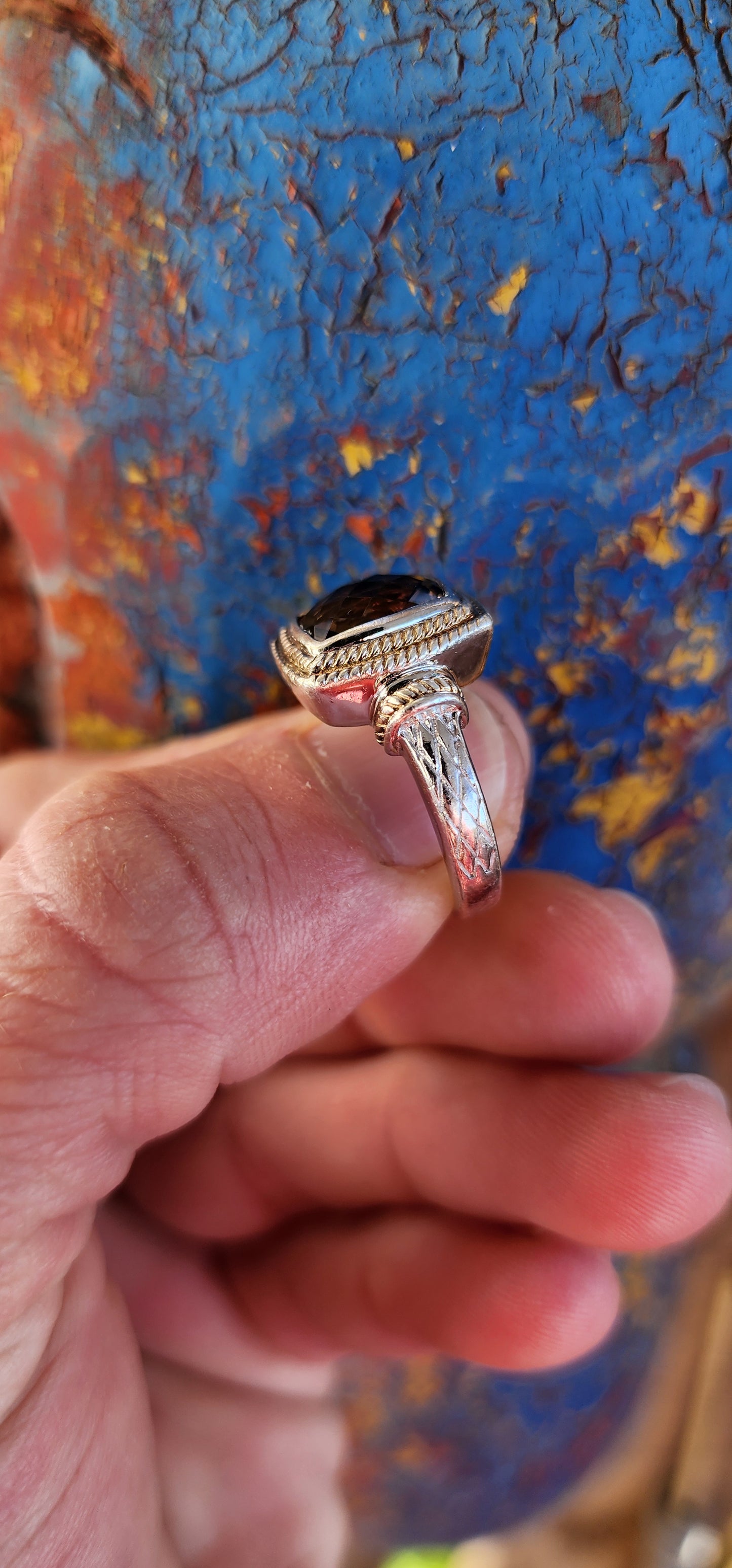 A beautifully made Designer Sterling Silver ring showcasing a Checkerboard faceted Rectangular Cushion cut Smoky Quartz Gemstone, bezel/tube set and positioned in the center.
The Smoky Quartz is encircled by a double cable halo.