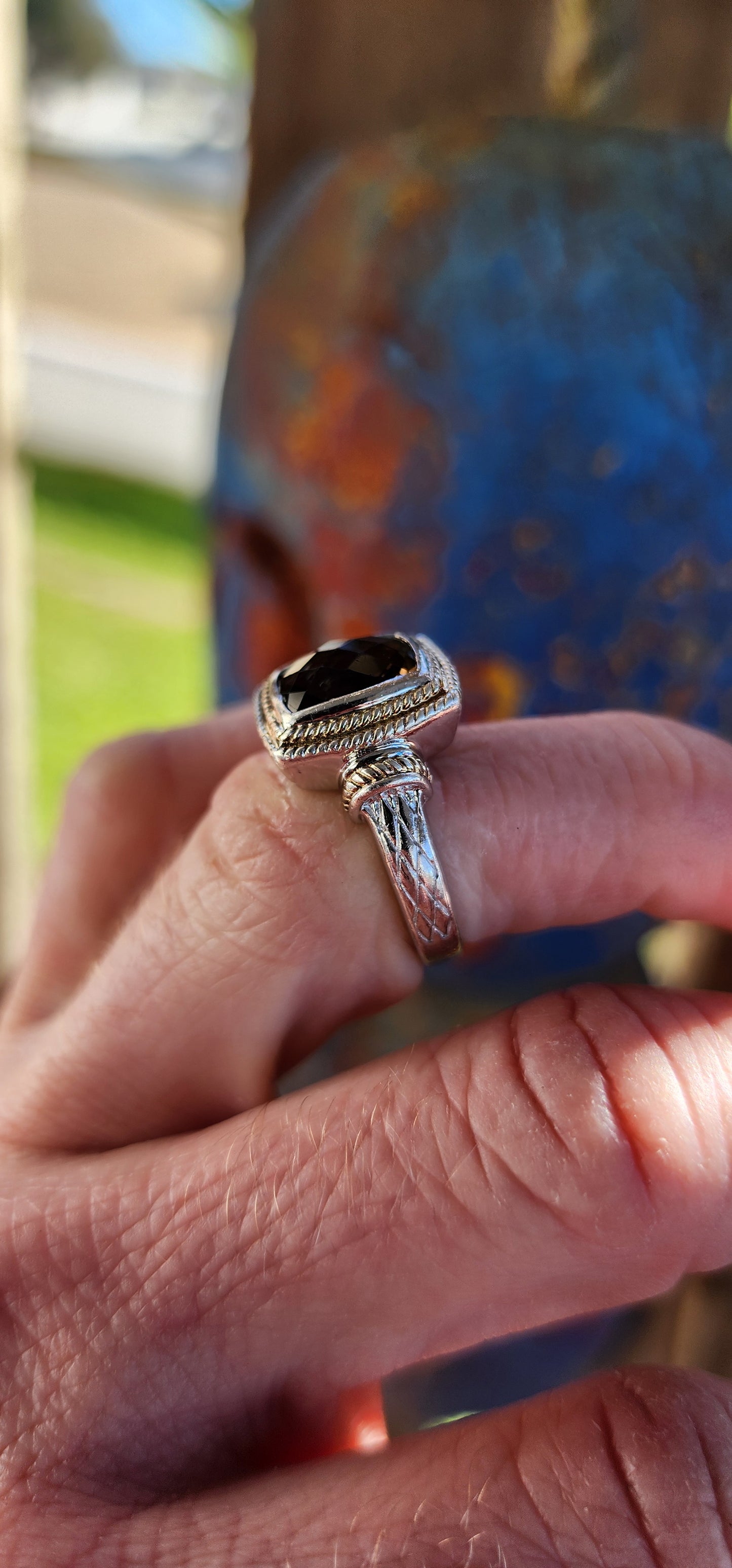 A beautifully made Designer Sterling Silver ring showcasing a Checkerboard faceted Rectangular Cushion cut Smoky Quartz Gemstone, bezel/tube set and positioned in the center.
The Smoky Quartz is encircled by a double cable halo.