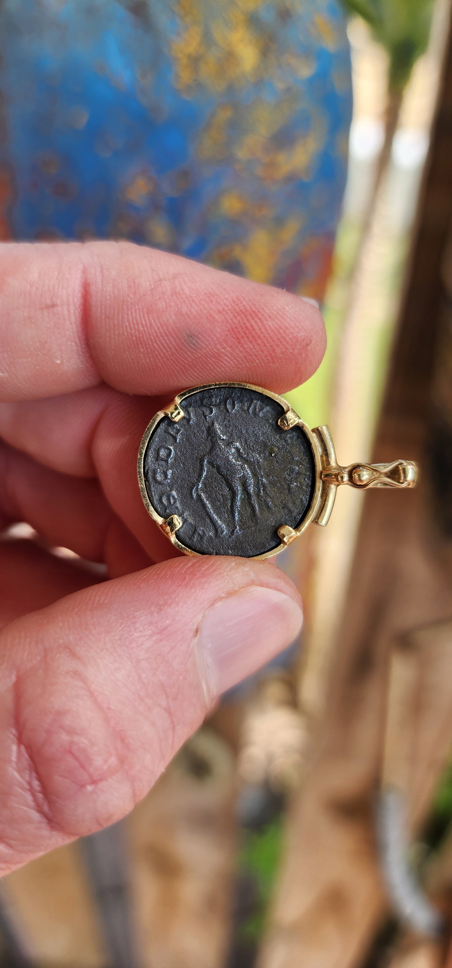 A fabulous Ancient Roman Bronze coin pendant featuring Postumus Antoninianus in a 8ct Yellow Gold bezel with open/close bail.
This pendant features a true Ancient Roman Bronze coin that was lightly circulated and depicts Postumus Antoninianus 260-269 AD.