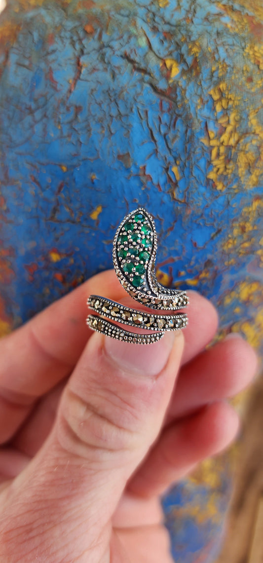 The elaborate Sterling Silver Serpent ring skillfully wraps itself around one's finger and heart.It has lovely scales composed of sparkly Marcasites, which shimmer beautifully in the light.