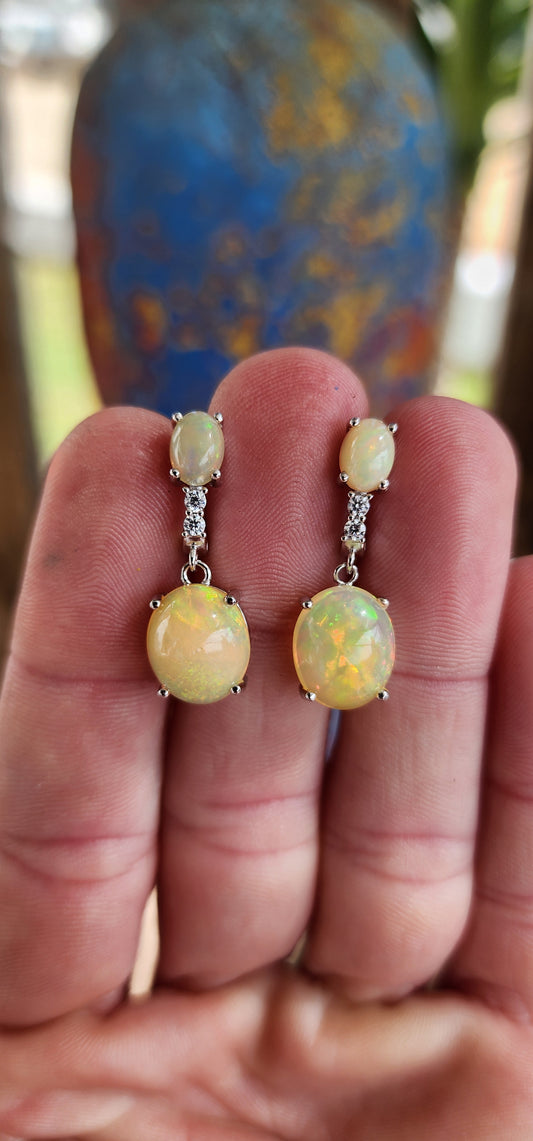 Stunning pair of Sterling Silver and Orange Ethiopian Welo Opal Cabochons and CZ Gemstones push-in earrings .These earrings from part of a matching set consisting out of Trilogy ring , earrings and pendant on chain .All Sold separately.