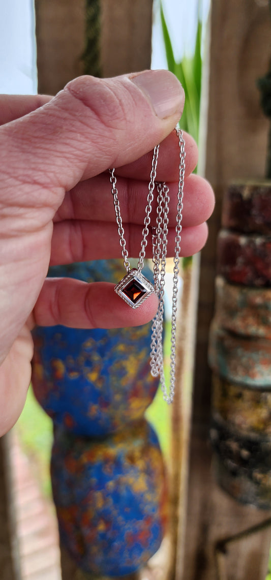 Minimalistic beauty - Beautiful and elegant Sterling Silver Cube pendant featuring a bezel/tube set Princess cut Almandine Garnet Gemstone with Rope motif border.