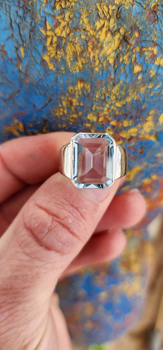 Stunning handcrafted unisex Sterling Silver ring showcases a gorgeous, large Emerald cut Sky Blue Topaz Gemstone set in a bezel/tube setting, with a tapered Silver band.Such an incredibly stunning ring!