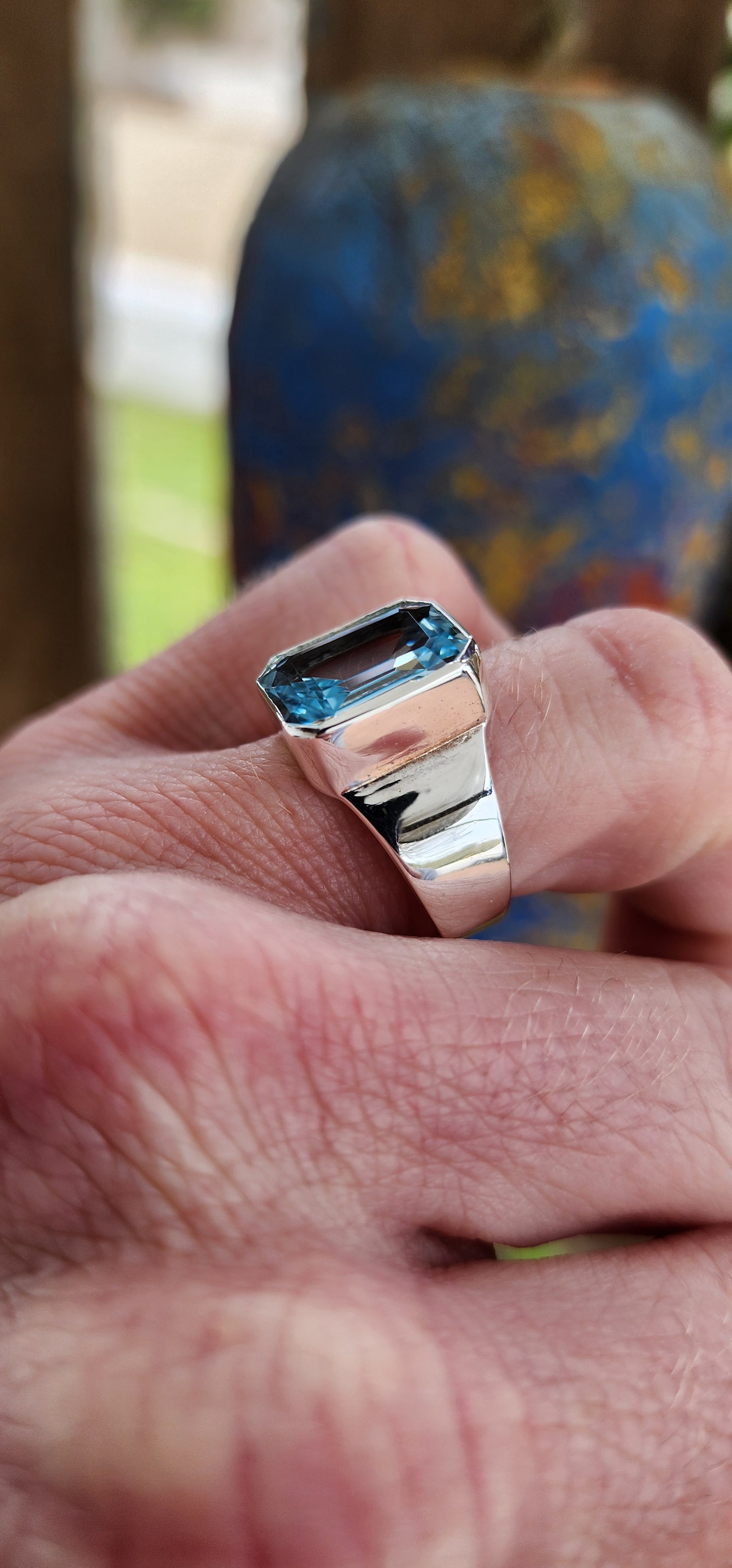 Stunning handcrafted unisex Sterling Silver ring showcases a gorgeous, large Emerald cut Sky Blue Topaz Gemstone set in a bezel/tube setting, with a tapered Silver band.Such an incredibly stunning ring!