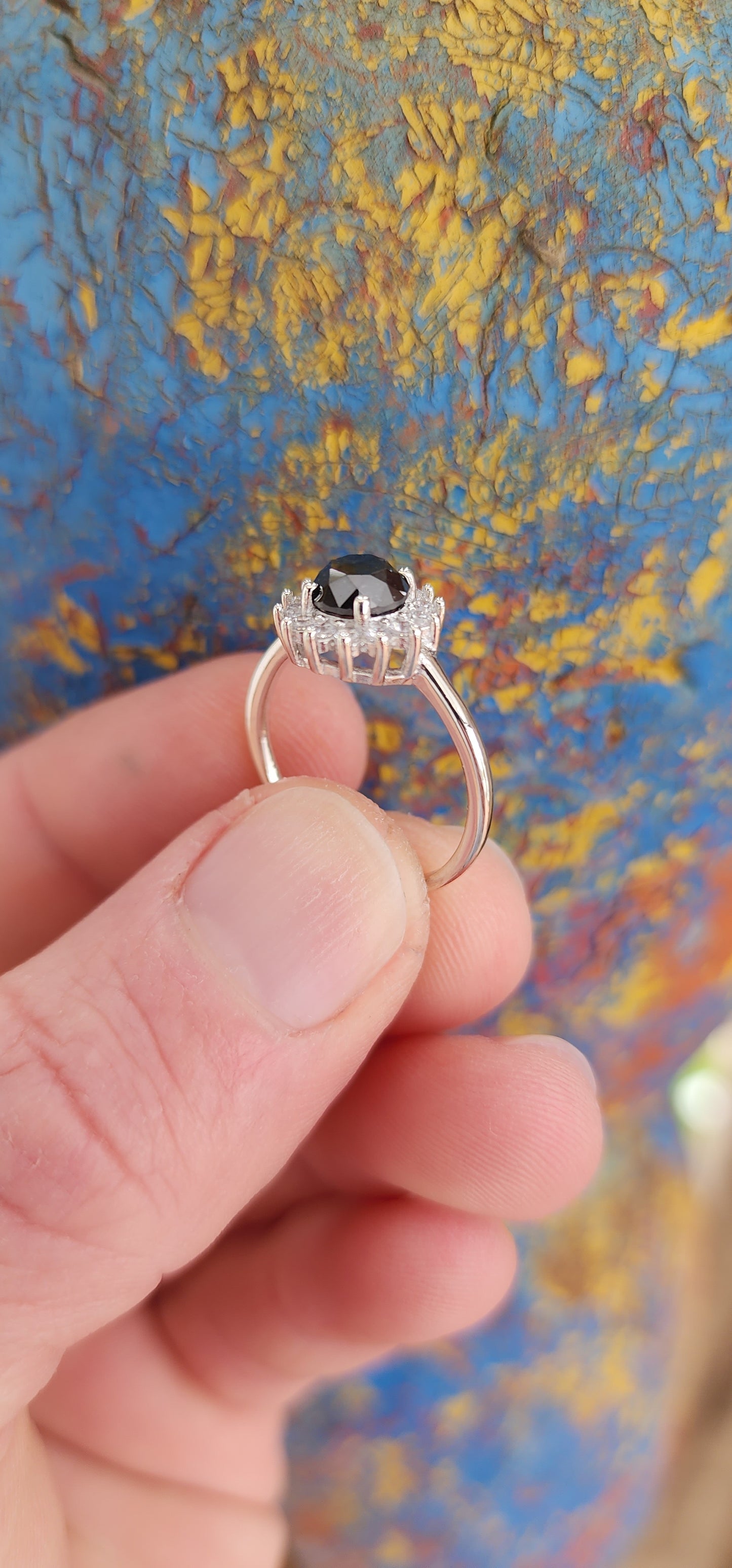 Elegant Solitaire/halo ring showcasing a stunning Round Black Diamond haloed by sparkling White CZ Gemstones.