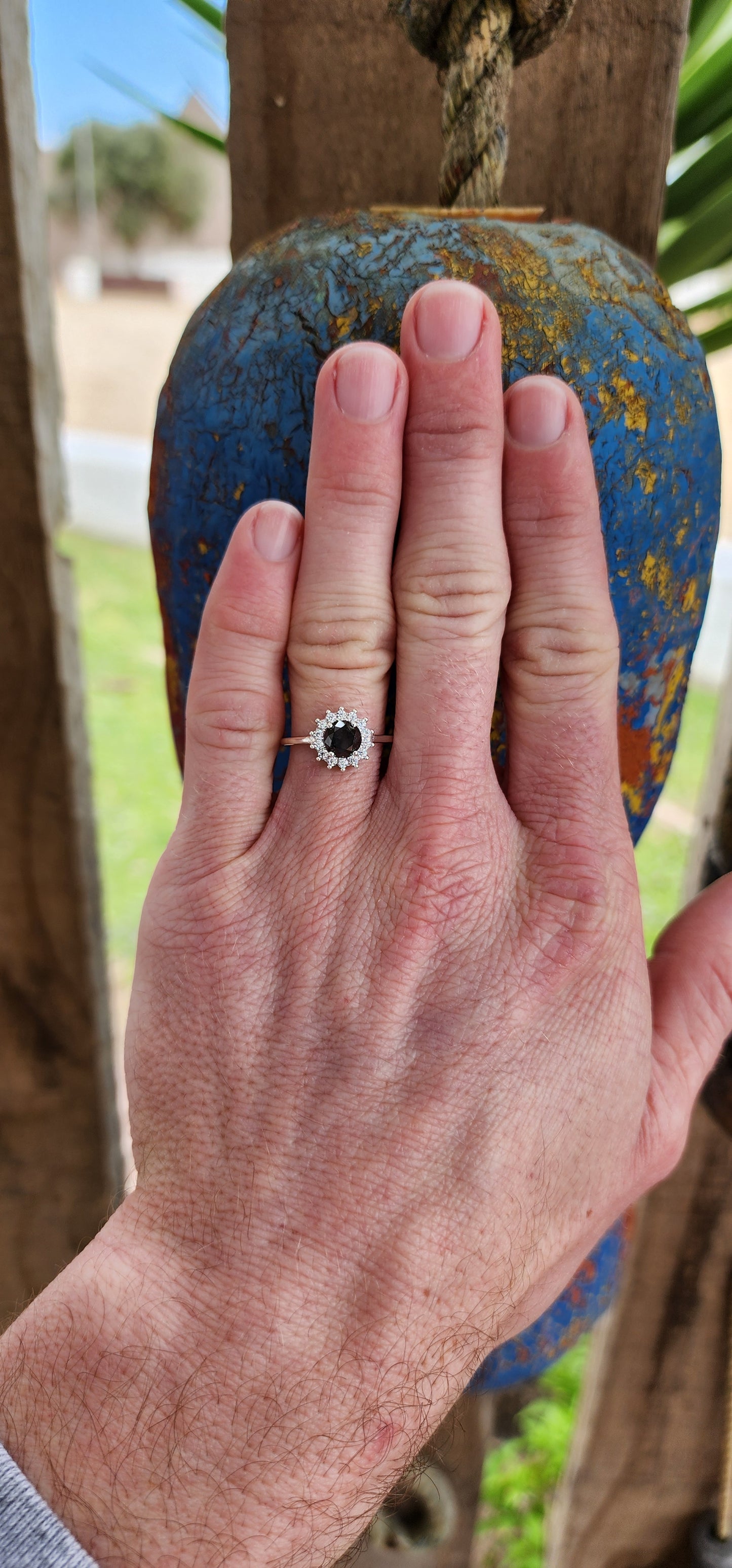 Elegant Solitaire/halo ring showcasing a stunning Round Black Diamond haloed by sparkling White CZ Gemstones.