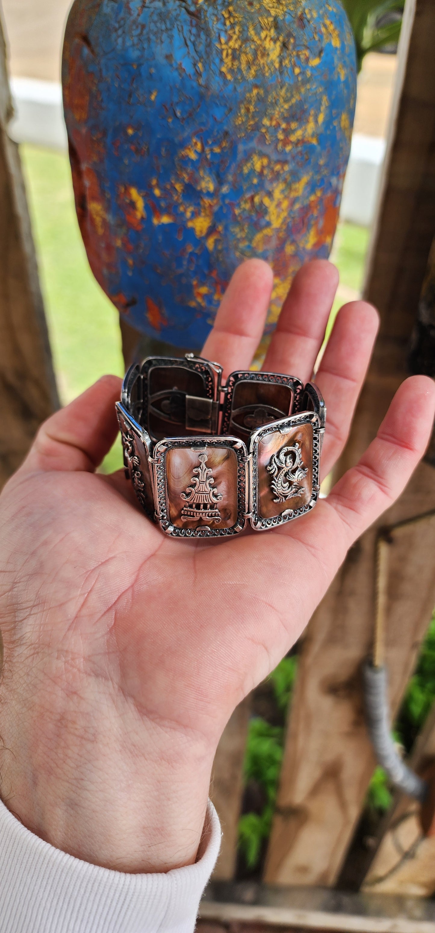 Antique Art Deco era circa 1920/30's 800 silver and Abelone Shell Oriental inspired panel bracelet.
Seven Rectangular Abelone Shell panels are each secured with prong settings in intricate filigree frames and are decorated with Oriental motifs.