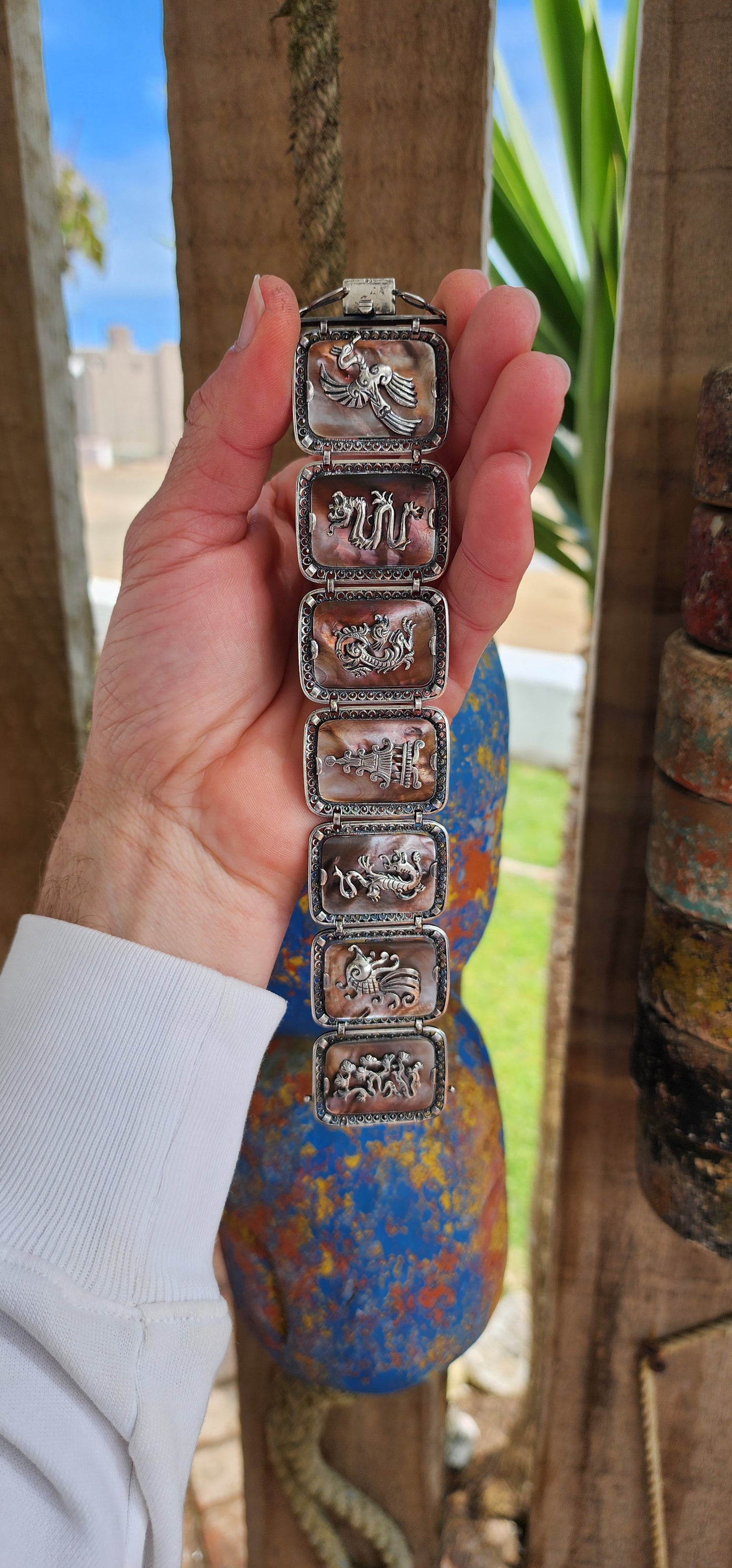 Antique Art Deco era circa 1920/30's 800 silver and Abelone Shell Oriental inspired panel bracelet.
Seven Rectangular Abelone Shell panels are each secured with prong settings in intricate filigree frames and are decorated with Oriental motifs.