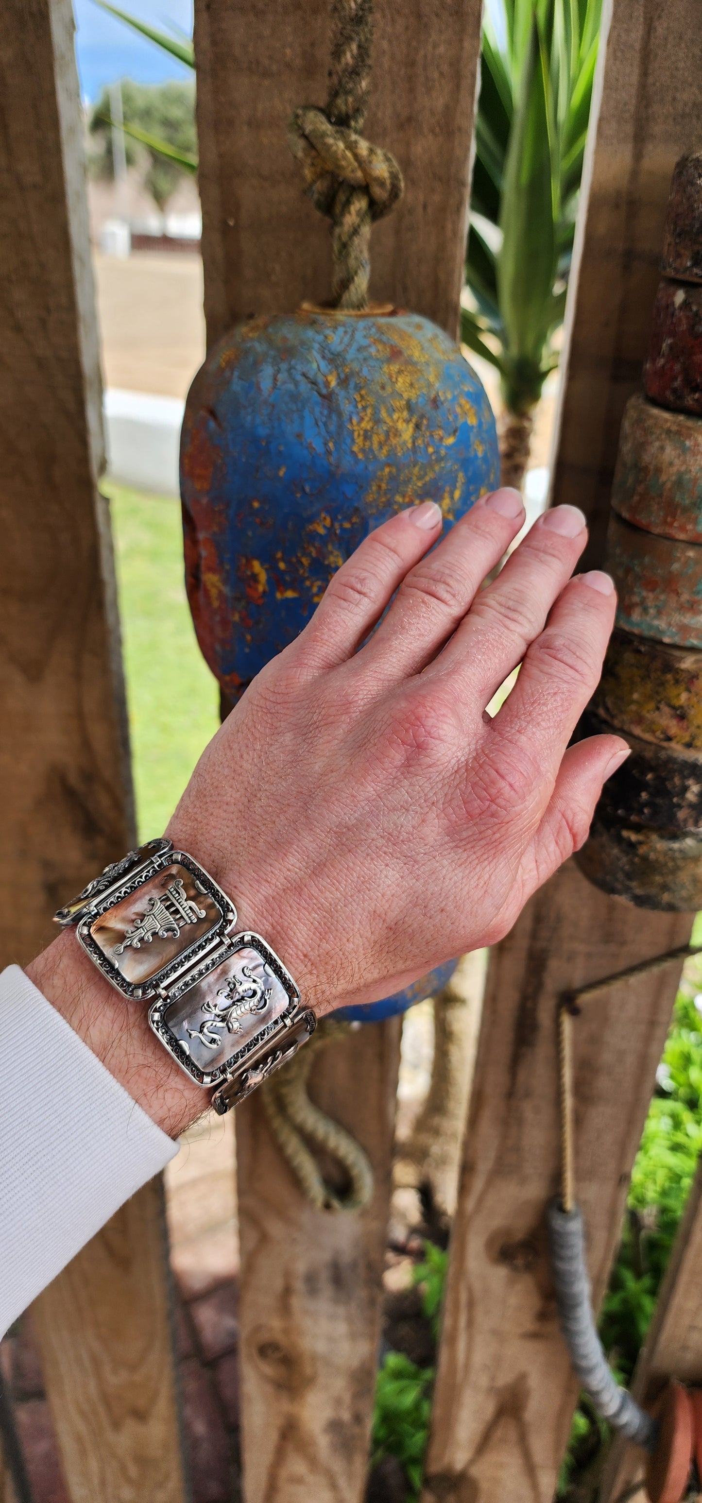 Antique Art Deco era circa 1920/30's 800 silver and Abelone Shell Oriental inspired panel bracelet.
Seven Rectangular Abelone Shell panels are each secured with prong settings in intricate filigree frames and are decorated with Oriental motifs.