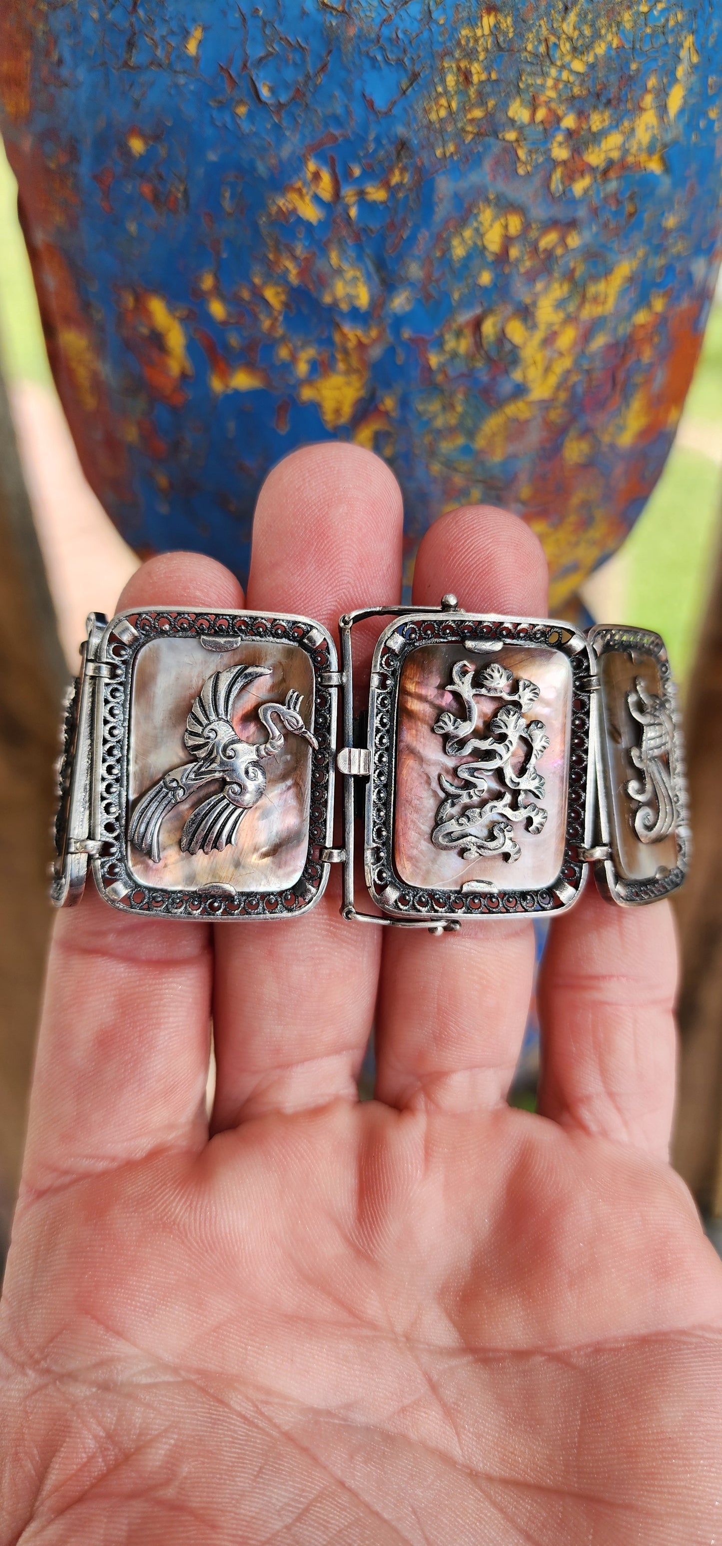 Antique Art Deco era circa 1920/30's 800 silver and Abelone Shell Oriental inspired panel bracelet.
Seven Rectangular Abelone Shell panels are each secured with prong settings in intricate filigree frames and are decorated with Oriental motifs.