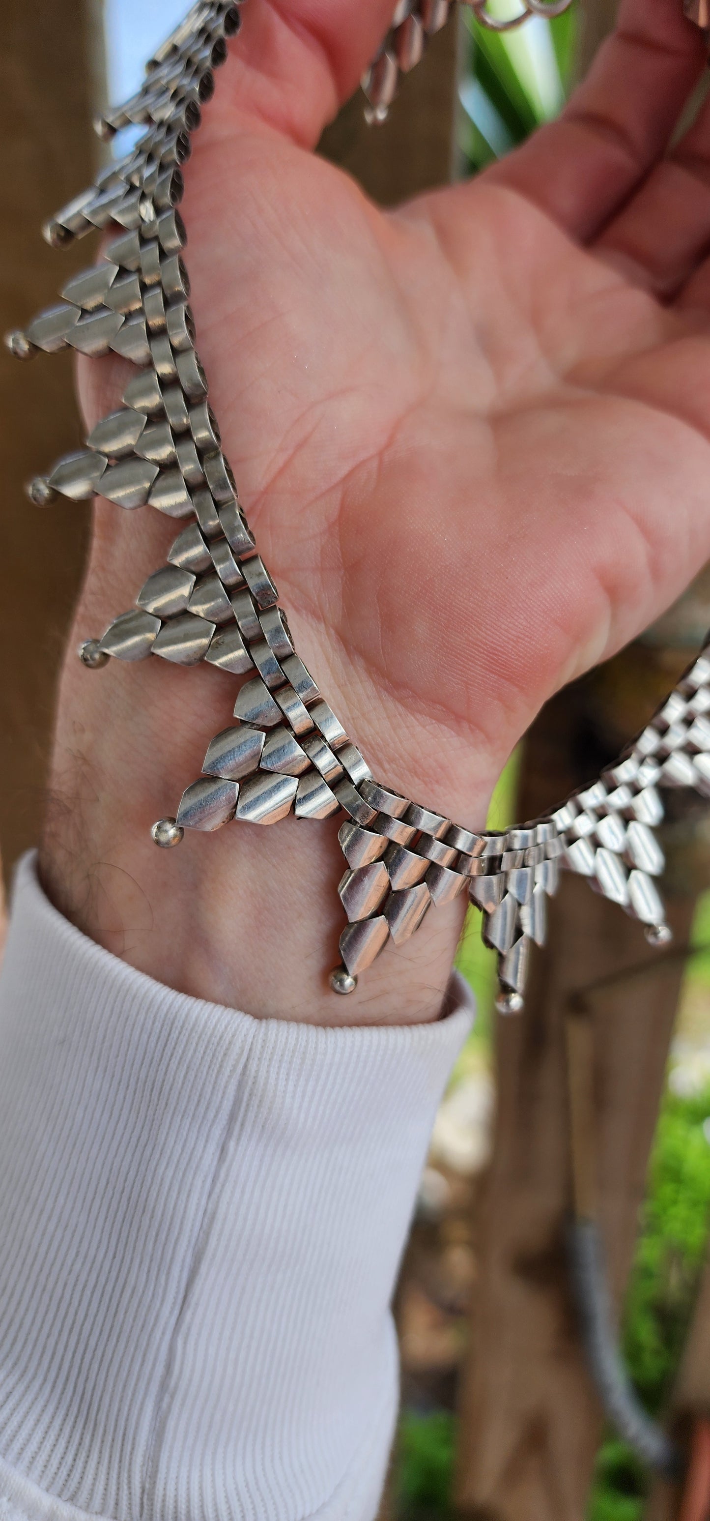 This gorgeous Antique circa 1880's Victorian Hallmarked Silver Etruscan revival articulated book chain collar necklace is made of intricate alternating links with cascading Triangular drops accented with orb edging.