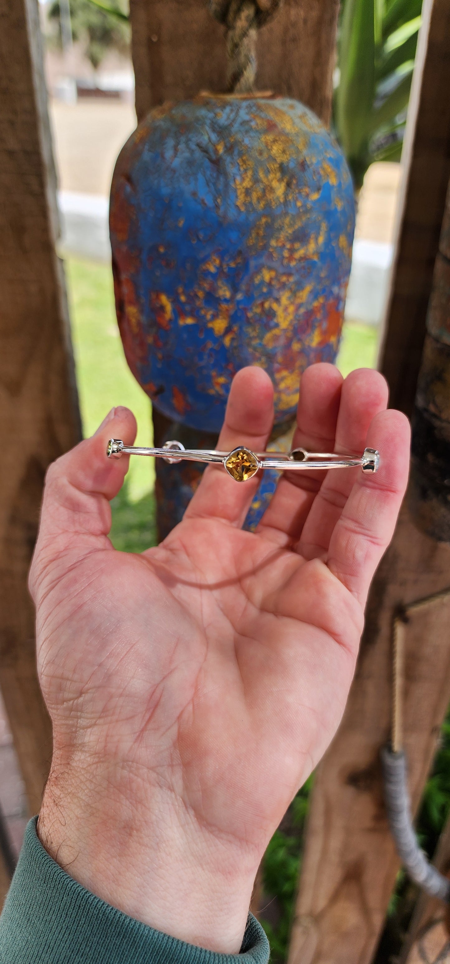 Artsy Sterling Silver ,Citrine, Peridot and Topaz Gemstones bangle.This gorgeous Sterling Silver tube bangle is bezel set with a lovely combinations of Gemstones including 1x Cushion cut Citrine , 2x Oval cut Peridots and 2x Round cut Blue Topaz Gemstones