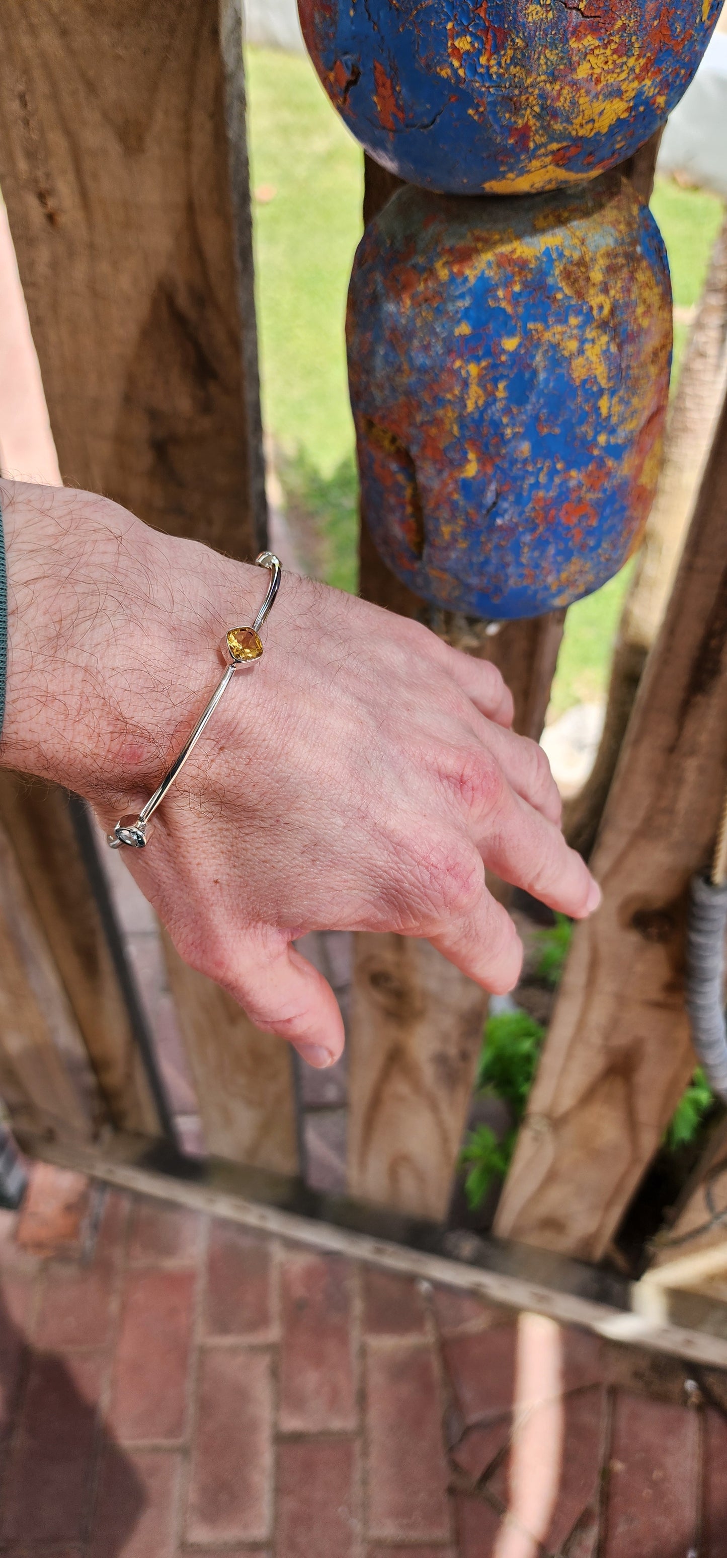 Artsy Sterling Silver ,Citrine, Peridot and Topaz Gemstones bangle.This gorgeous Sterling Silver tube bangle is bezel set with a lovely combinations of Gemstones including 1x Cushion cut Citrine , 2x Oval cut Peridots and 2x Round cut Blue Topaz Gemstones