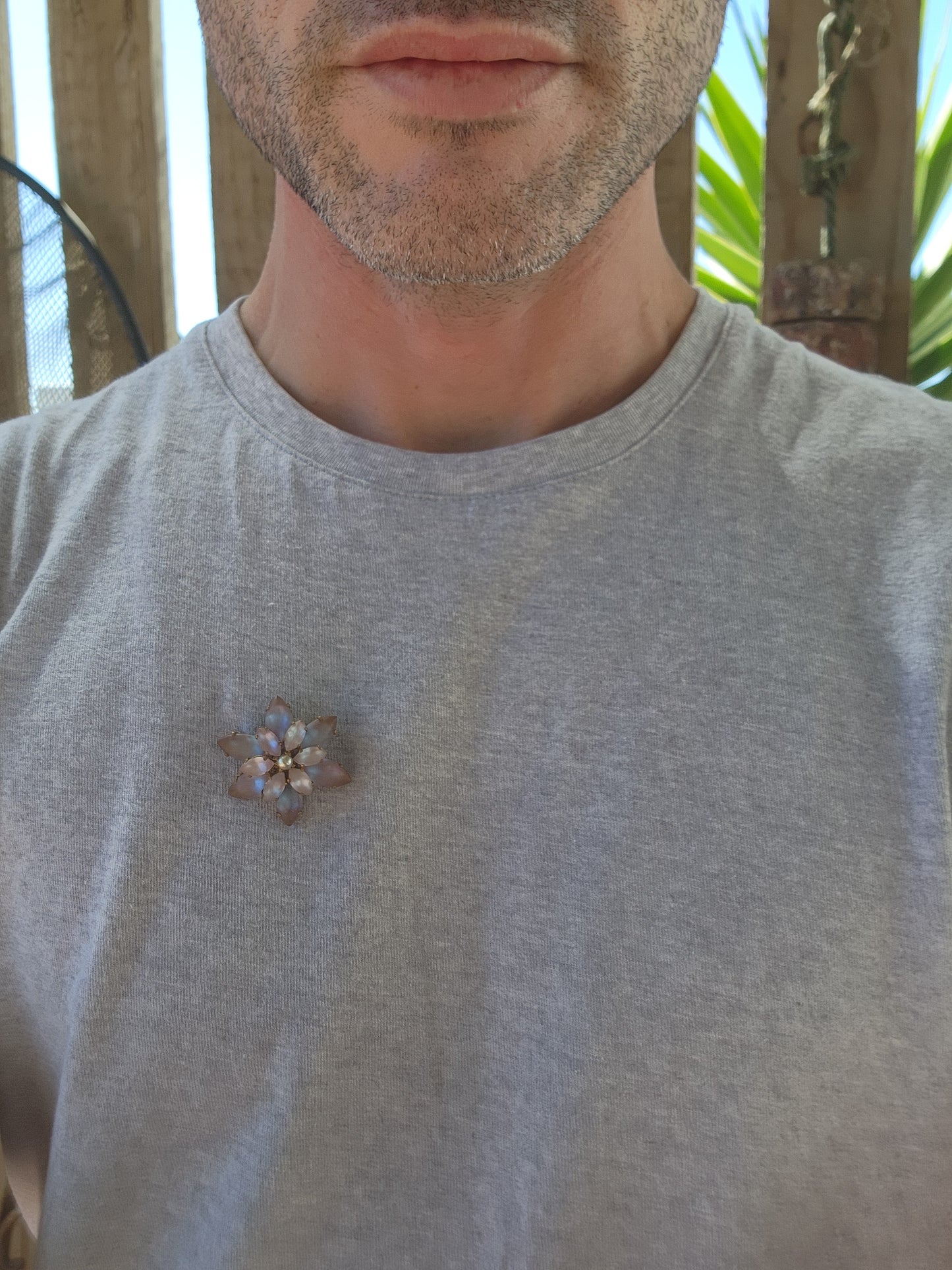 This Vintage brooch, likely from the 1950s, has a beautiful floral design. The centerpiece is a faux pearl, surrounded by two layers of Marquise-cut Sappharine glass stones.