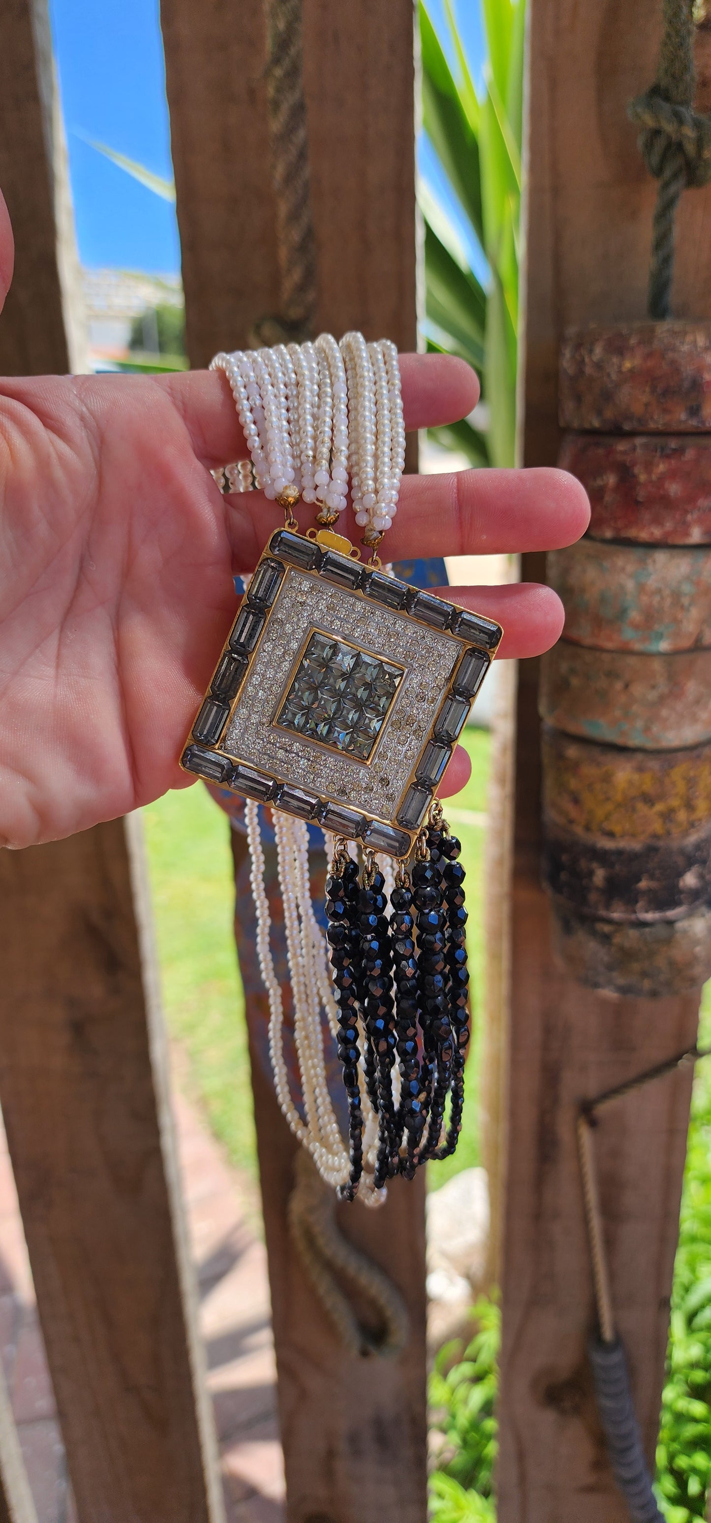 This statement necklace is a striking piece of vintage costume jewelry from the 1980s, designed in an Art Deco-inspired style.