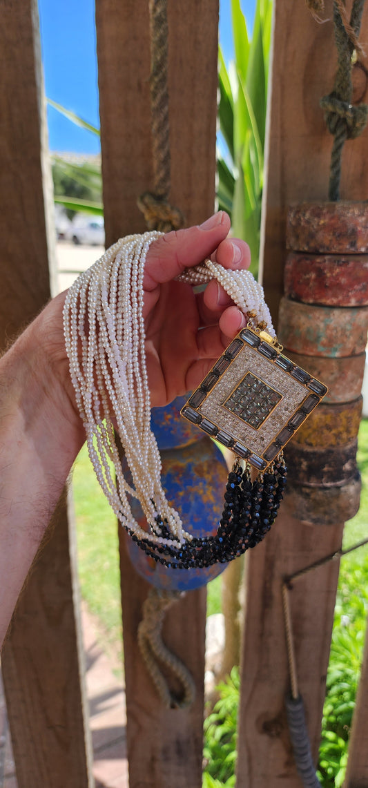 This statement necklace is a striking piece of vintage costume jewelry from the 1980s, designed in an Art Deco-inspired style.