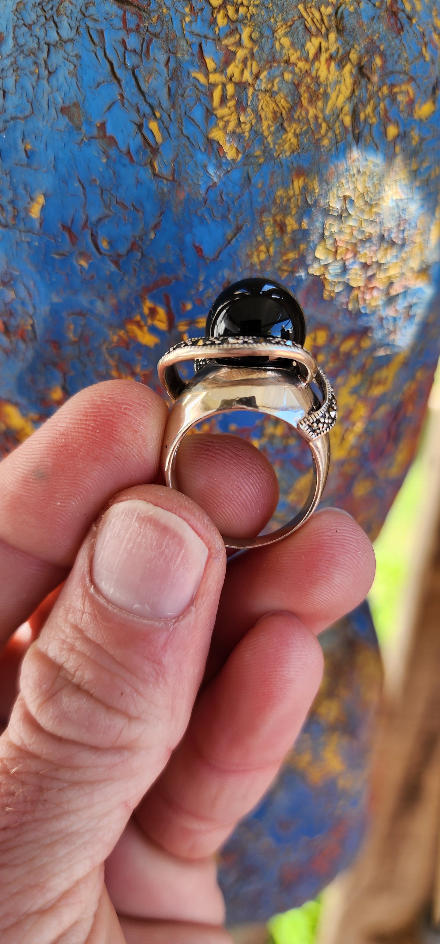 This chunky dress ring is a beautiful, Art Deco-inspired piece crafted in sterling silver. It features a prominent, spherical onyx stone at its center, often referred to as a "floating orb" due to the way it is set slightly elevated above the band.