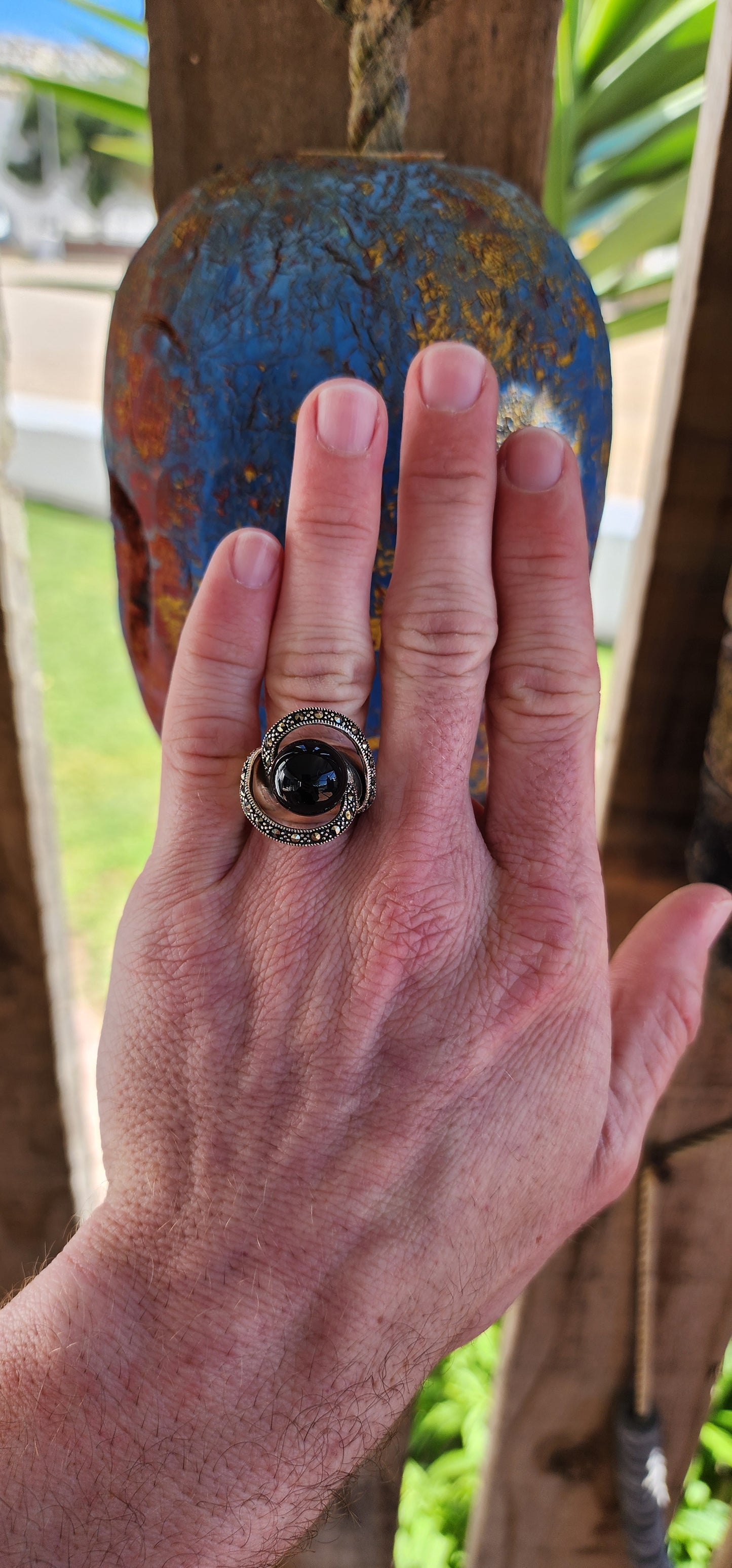 This chunky dress ring is a beautiful, Art Deco-inspired piece crafted in sterling silver. It features a prominent, spherical onyx stone at its center, often referred to as a "floating orb" due to the way it is set slightly elevated above the band.