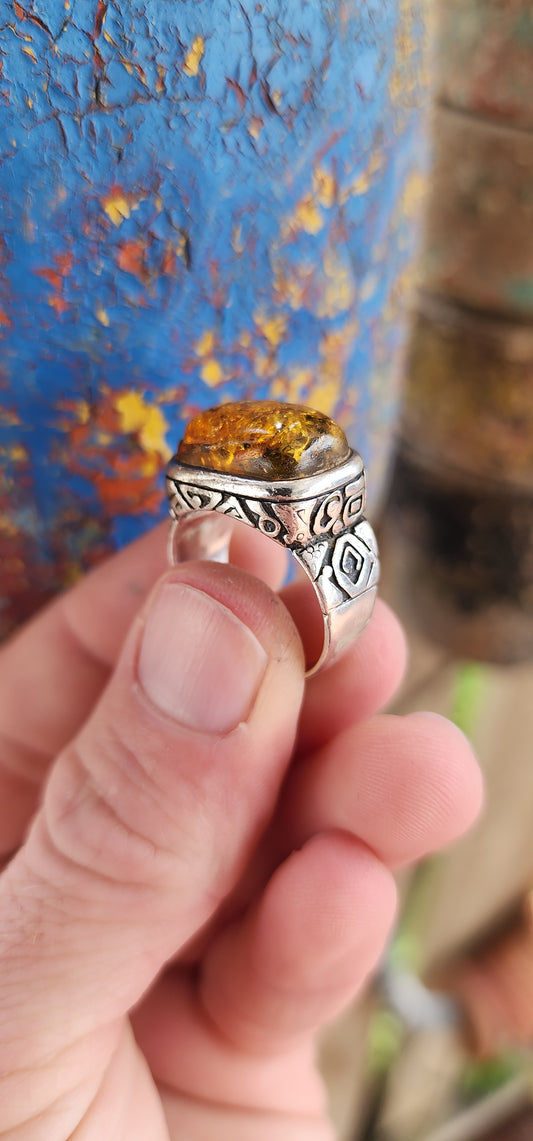 This stunning,vintage and bold ring is a beautiful fusion of timeless elegance and earthy warmth, anchored by the unmistakable charm of a large Baltic amber cabochon.