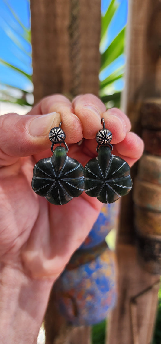 These earrings present a rich, earthy aesthetic that combines the elegance of sterling silver with the natural allure of serpentine gemstones. The design follows a layered structure that draws on organic and tribal/ethnic-inspired motifs.