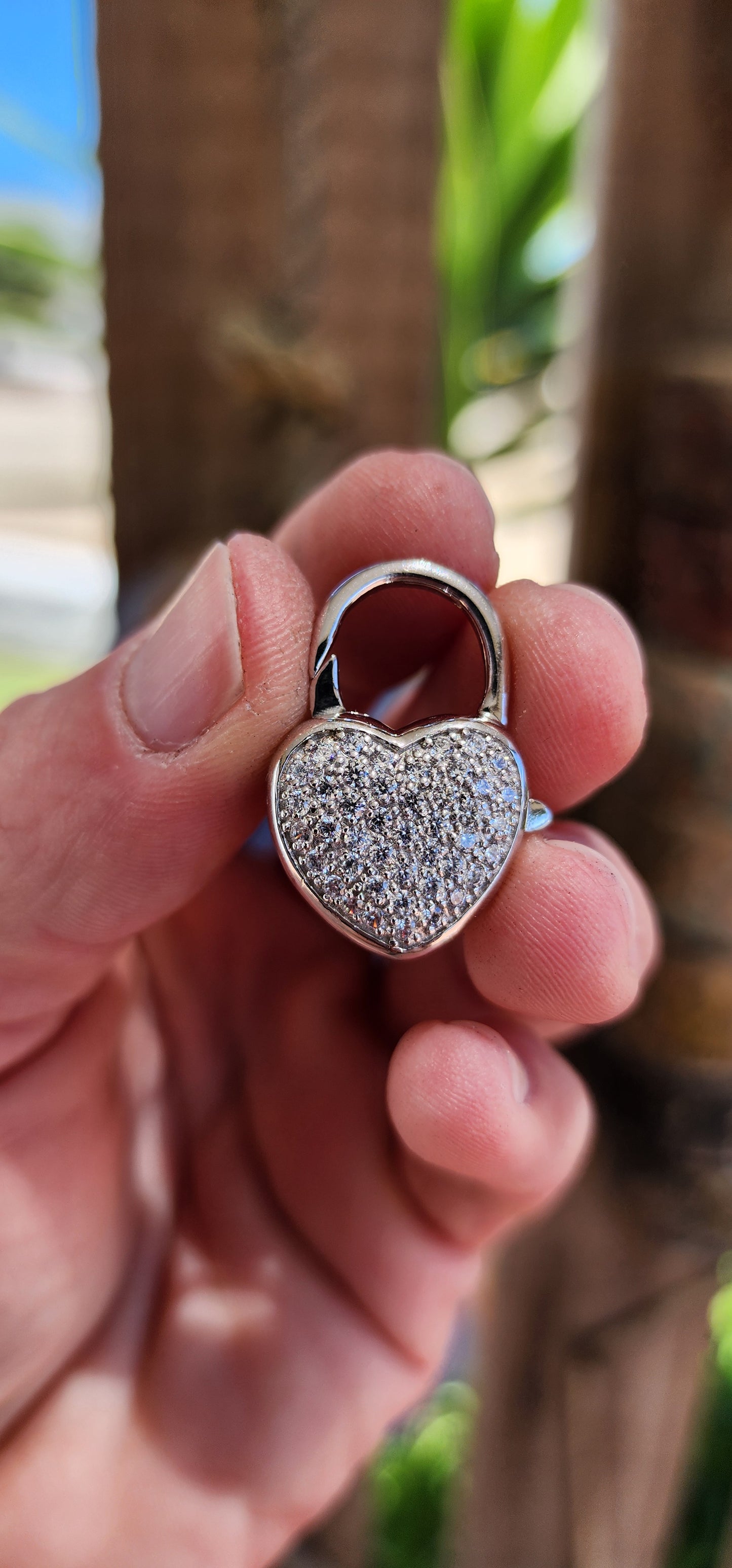 This exquisite clasp, designed as a puffed heart-shaped padlock, is crafted from gleaming sterling silver, its surface cool and smooth to the touch, yet radiating a warm allure.