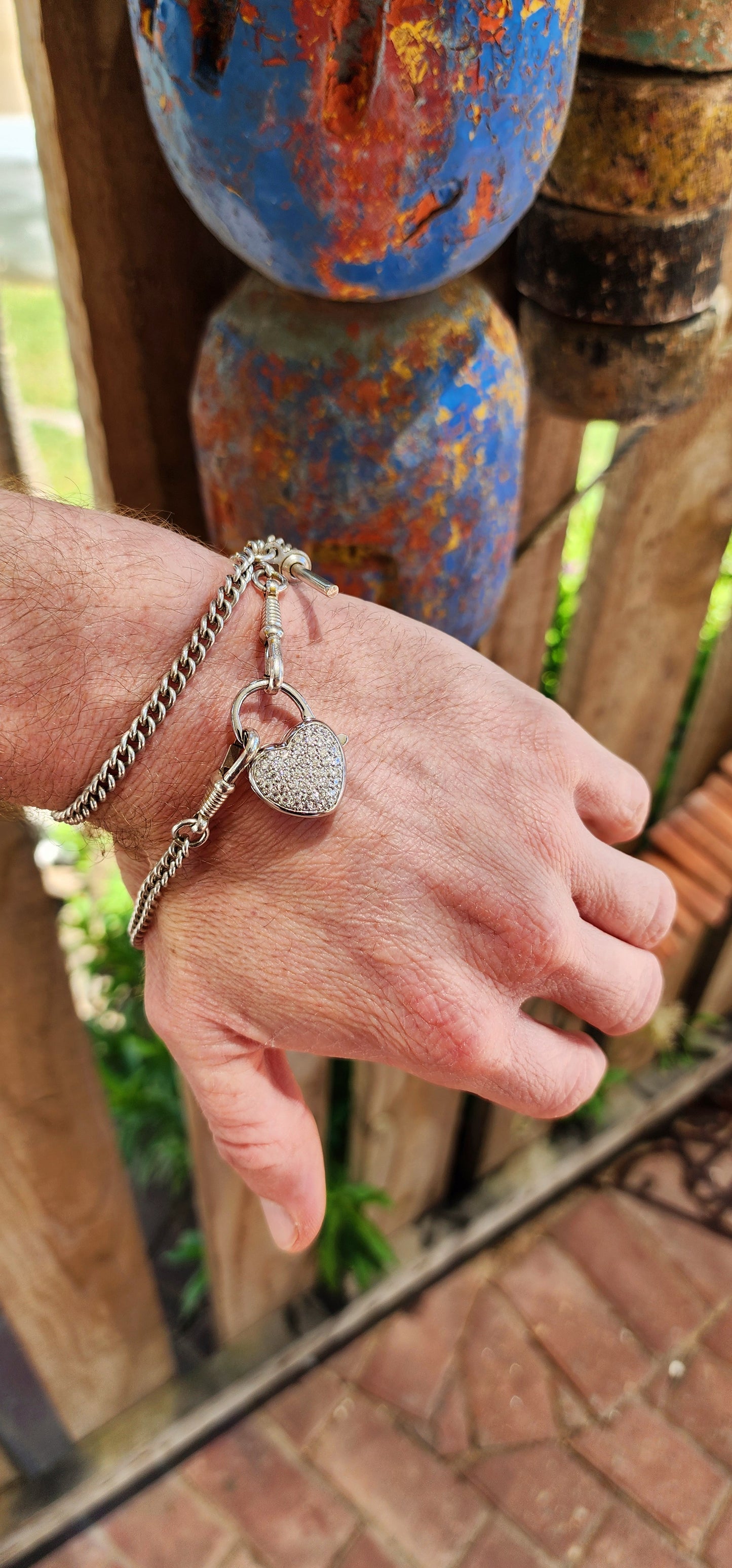 This exquisite clasp, designed as a puffed heart-shaped padlock, is crafted from gleaming sterling silver, its surface cool and smooth to the touch, yet radiating a warm allure.