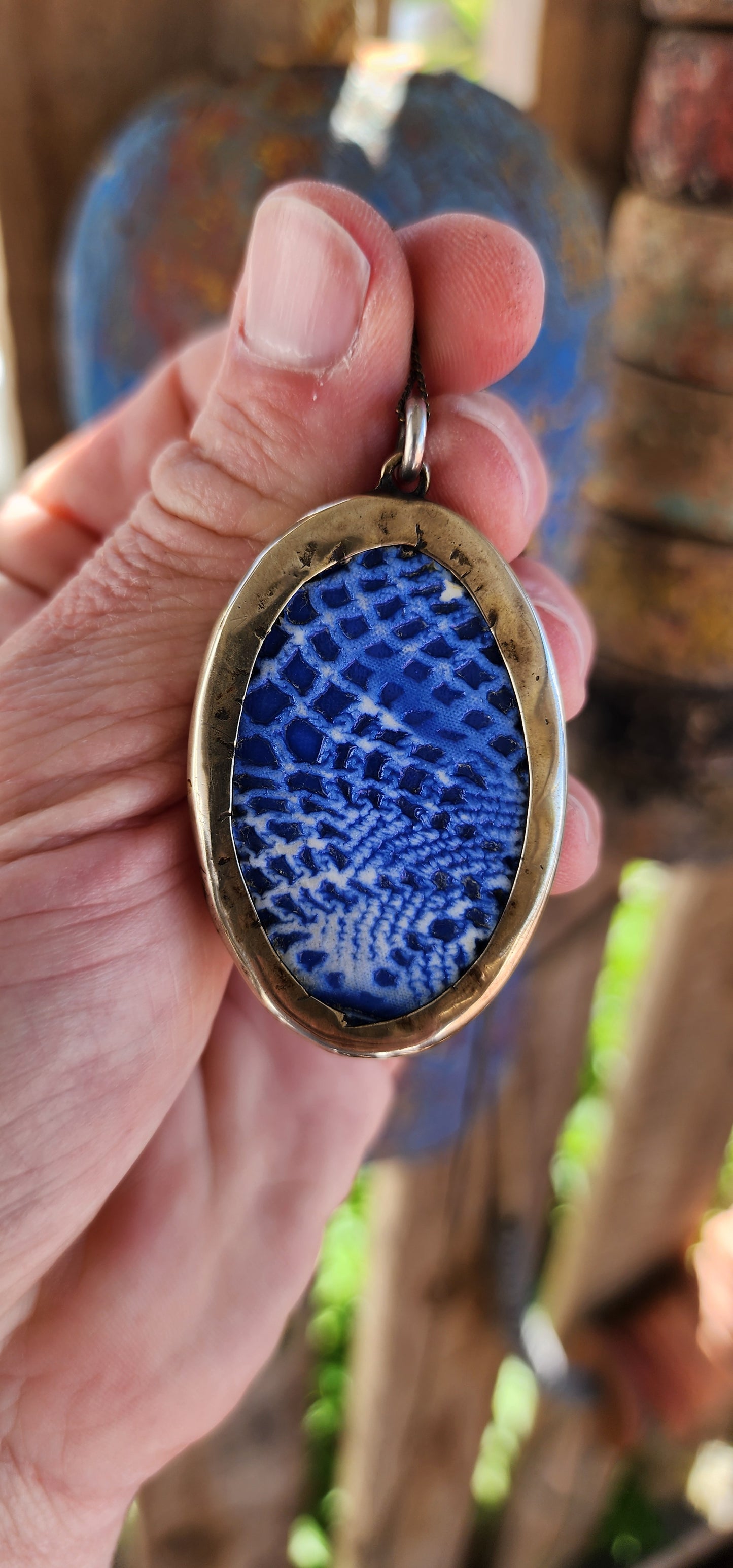 This unique Designer artisan-made pendant is a striking blend of artistry and cultural homage. Its oval shape frames a captivating blue glazed ceramic panel that presents an embossed depiction of an oriental figure.