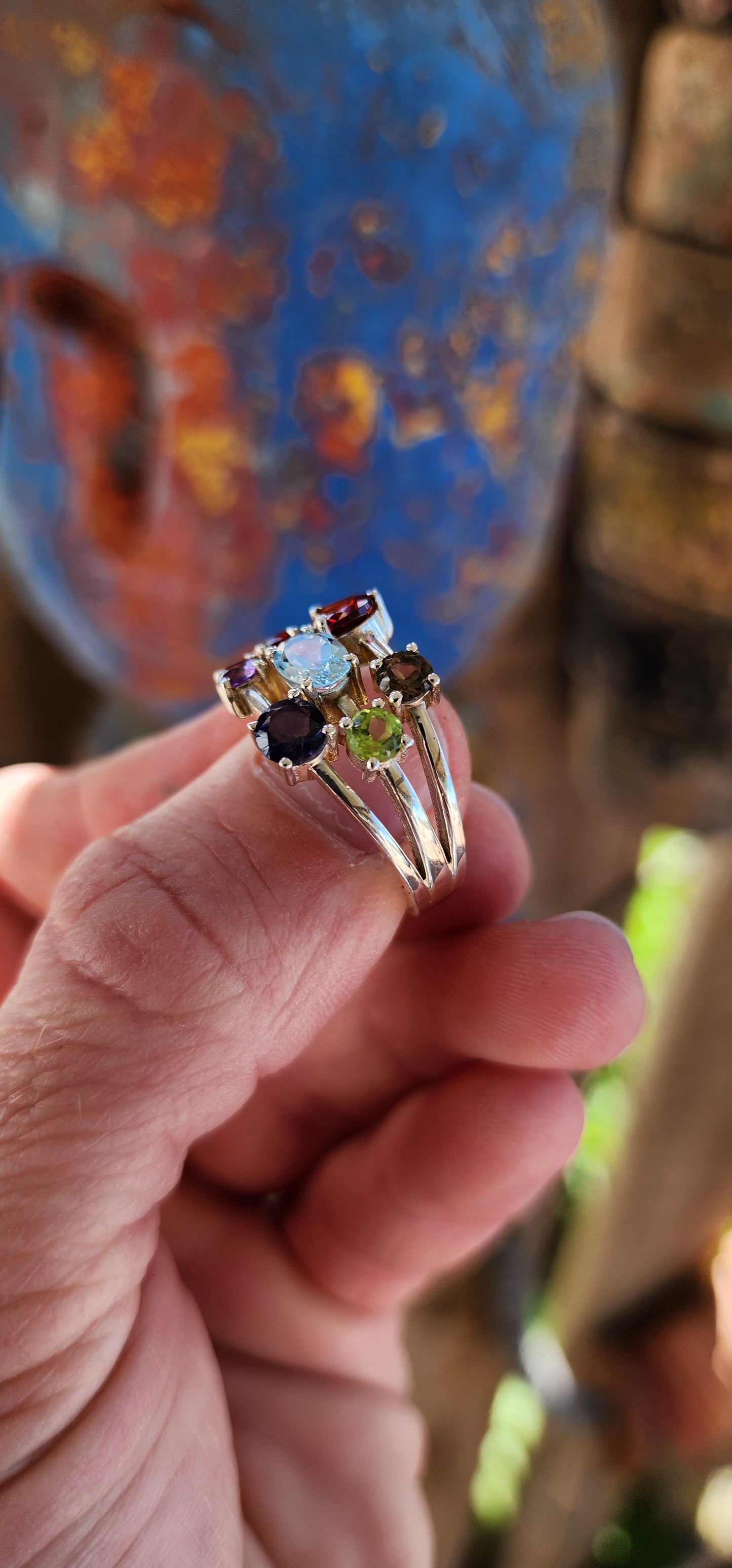 This chunky sterling silver beauty is like a rainbow party for your finger! Sporting a delicious "tutti frutti" lineup of gems, it’s a gemstone extravaganza with prong-set Iolite, Amethyst, Peridot, Topaz, Smoky Quartz, and fiery Garnets.