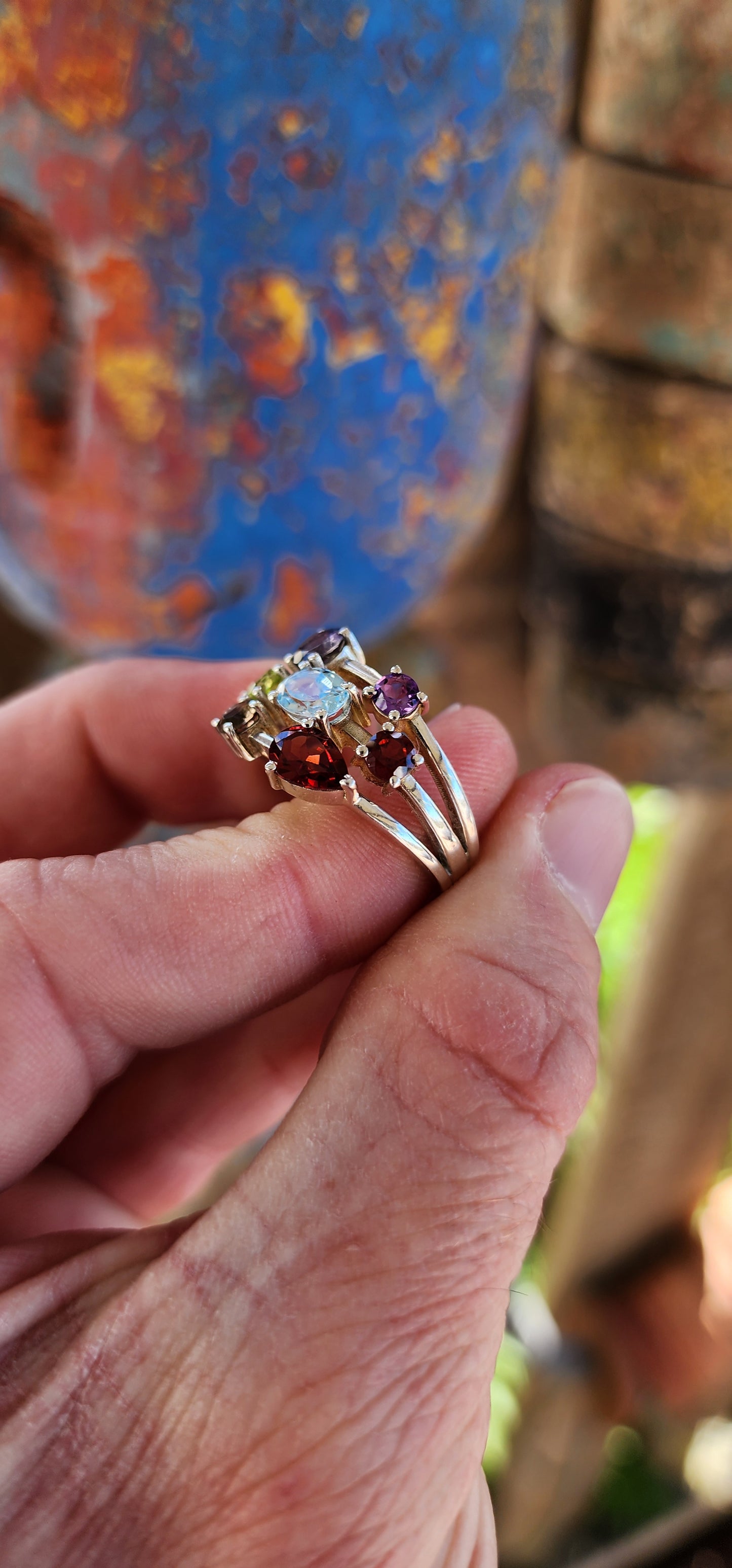 This chunky sterling silver beauty is like a rainbow party for your finger! Sporting a delicious "tutti frutti" lineup of gems, it’s a gemstone extravaganza with prong-set Iolite, Amethyst, Peridot, Topaz, Smoky Quartz, and fiery Garnets.