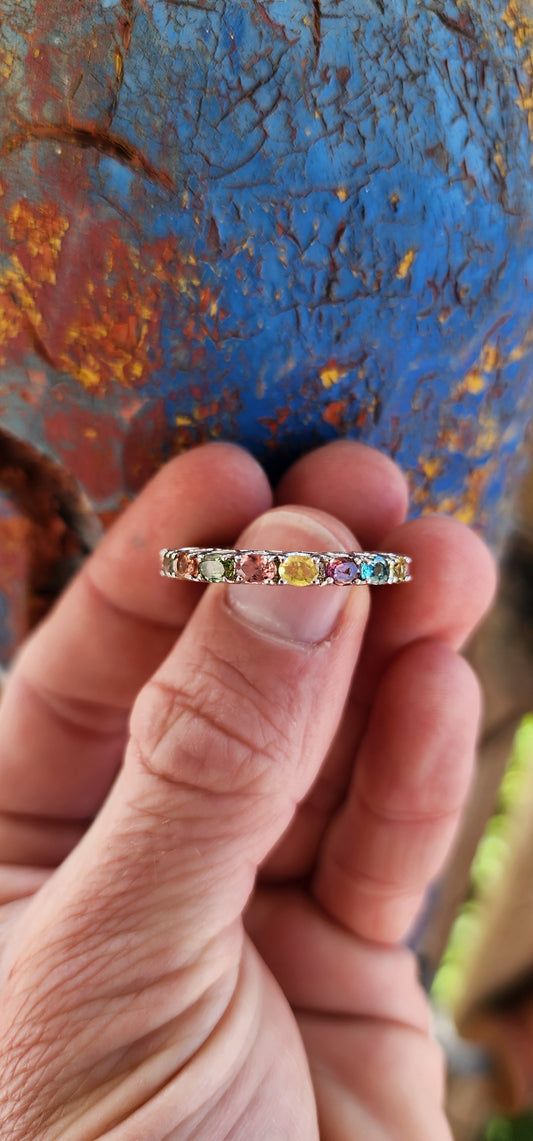 This full eternity ring is like a kaleidoscope you can wear on your finger! Imagine a carousel spinning with every color of the rainbow, frozen in a perfect loop of shimmering sterling silver.