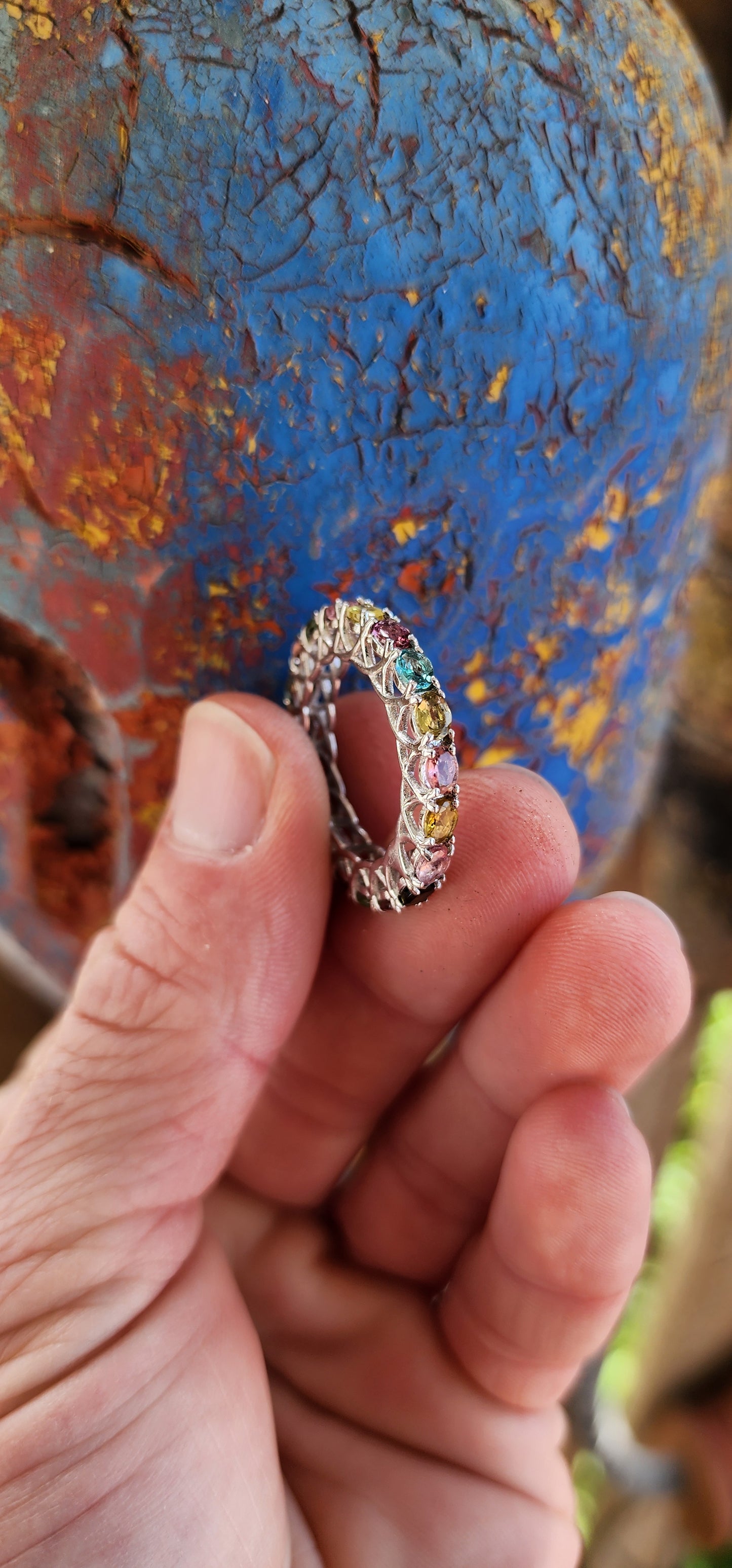 This full eternity ring is like a kaleidoscope you can wear on your finger! Imagine a carousel spinning with every color of the rainbow, frozen in a perfect loop of shimmering sterling silver.