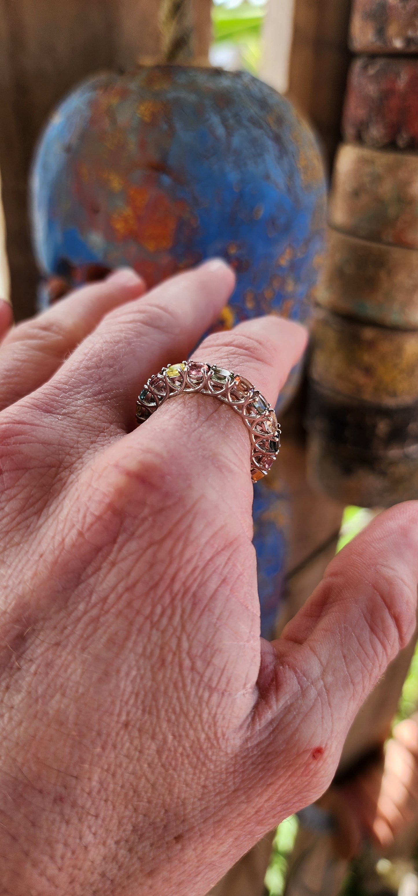 This full eternity ring is like a kaleidoscope you can wear on your finger! Imagine a carousel spinning with every color of the rainbow, frozen in a perfect loop of shimmering sterling silver.