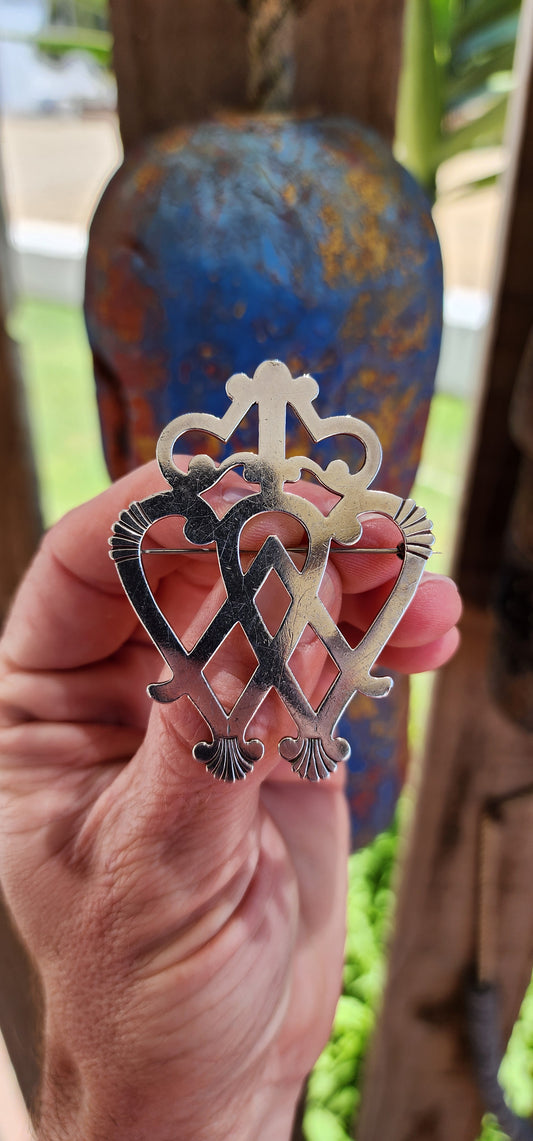 Marvelous and large sized antique Victorian Scottish Luckenbooth brooch.The large sterling silver brooch features the classic design of two interlocking hearts topped with a crown, a symbol rich in romantic and cultural significance.