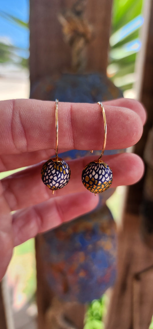 These designer costume earrings are playful and vibrant showstoppers, featuring soft satin fabric spheres in a kaleidoscope of bold colors and patterns.