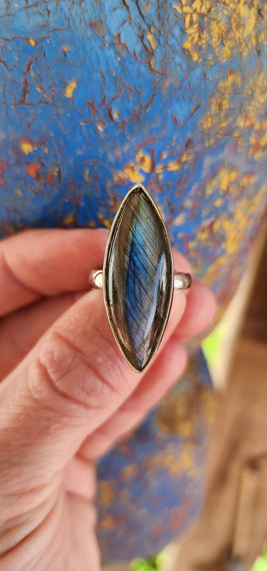 This striking dress ring is the epitome of earthy elegance with a celestial twist. Its sterling silver band features a bold marquise-cut labradorite cabochon, capturing the eye with its signature shimmer.