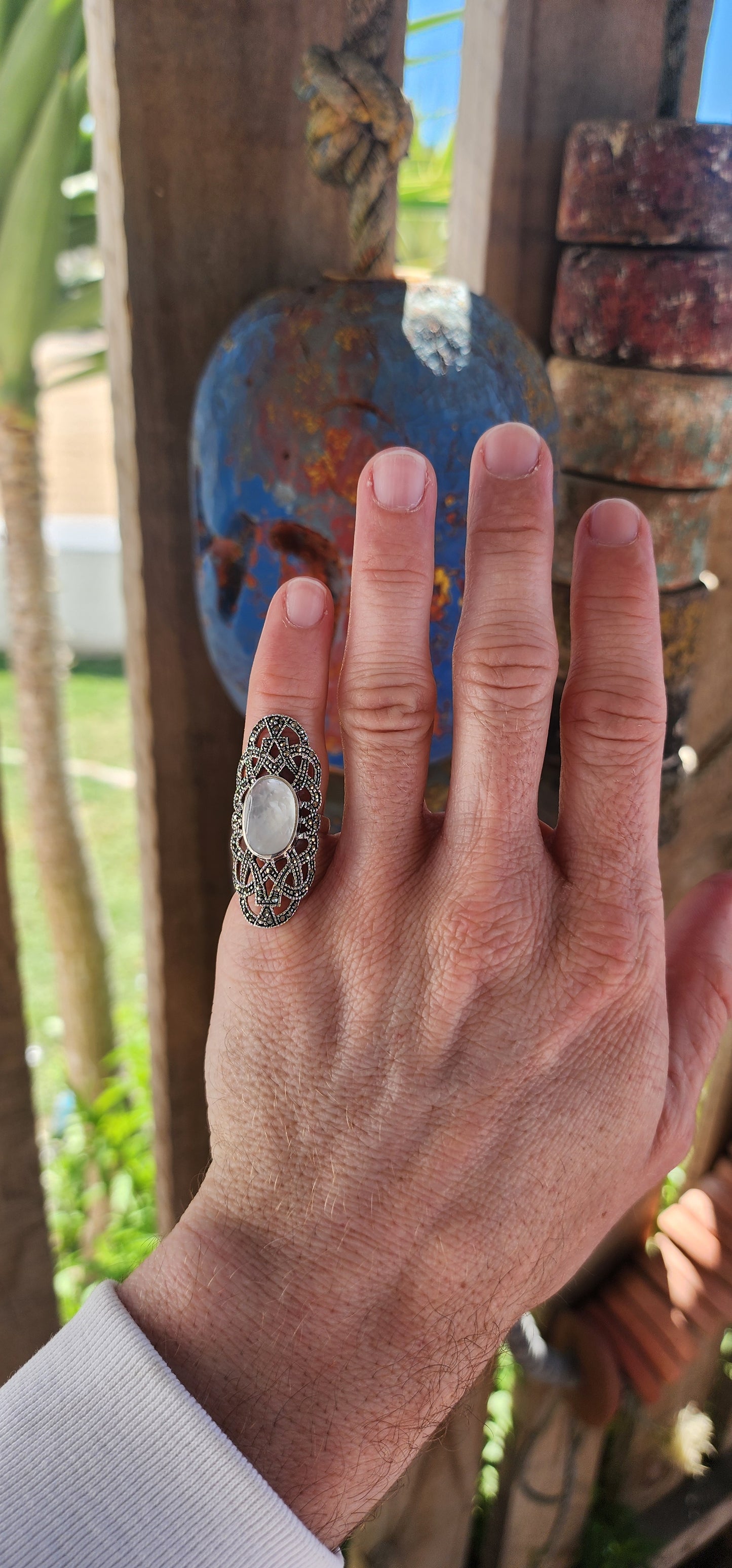 Nestled in the cradle of a sterling silver filigree lattice, this ethereal ring whispers of ancient secrets and lunar enchantments. Its centerpiece—a luminous oval cabochon of mother-of-pearl—glows like a shard of the moon, forever caught in twilight.