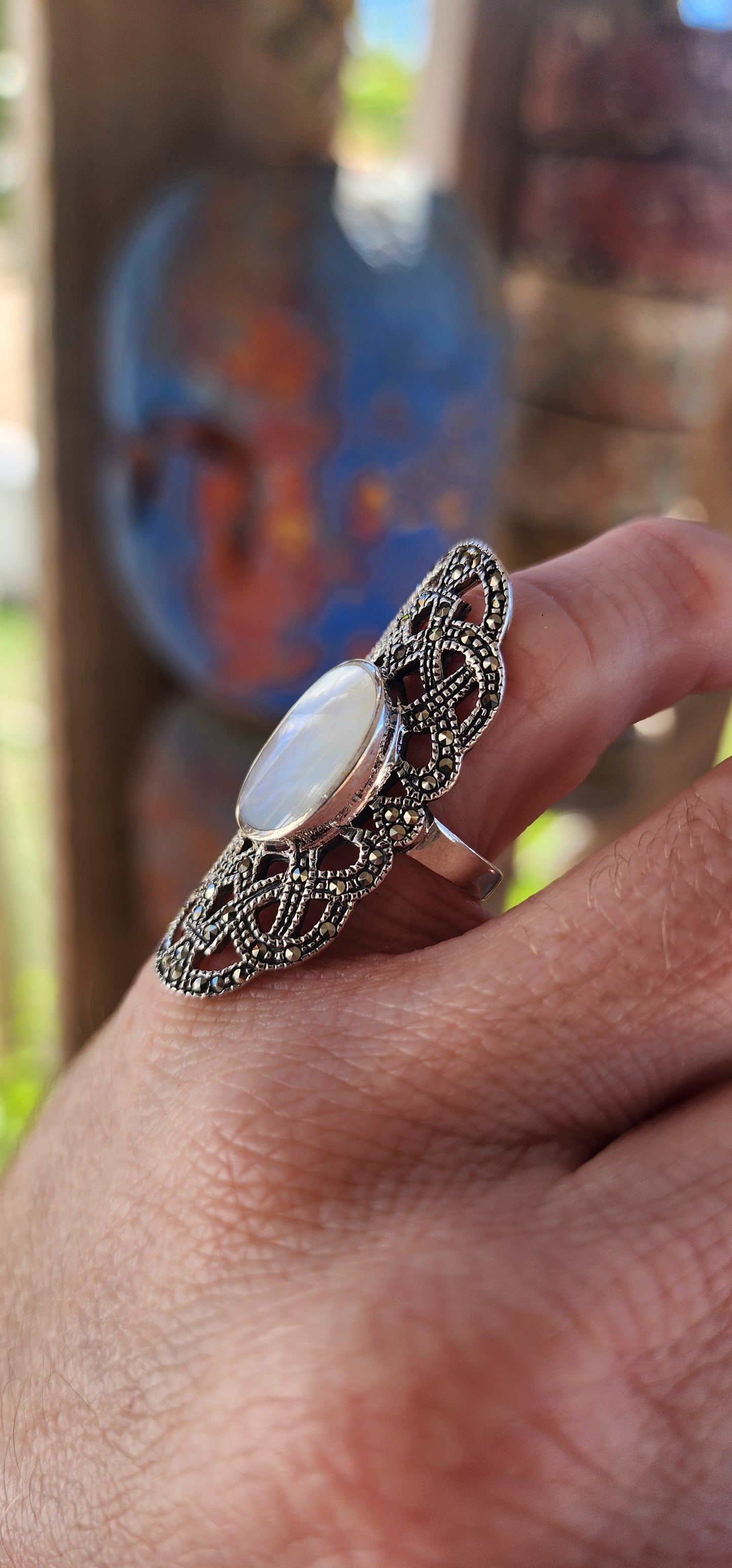 Nestled in the cradle of a sterling silver filigree lattice, this ethereal ring whispers of ancient secrets and lunar enchantments. Its centerpiece—a luminous oval cabochon of mother-of-pearl—glows like a shard of the moon, forever caught in twilight.