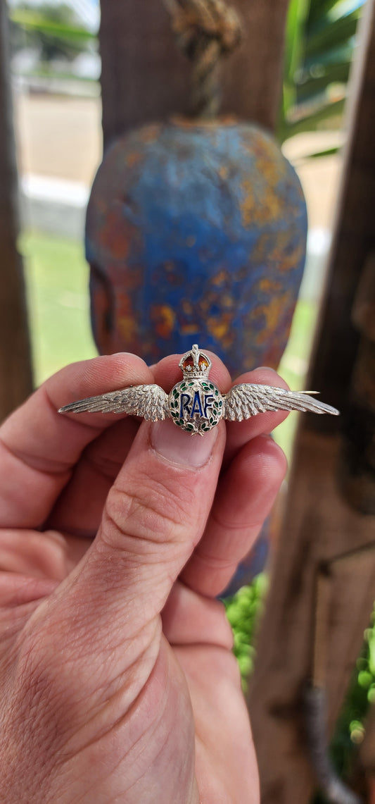 This brooch is a classic example of a World War II Royal Air Force (RAF) sweetheart brooch, crafted in sterling silver and adorned with vibrant enamel work.