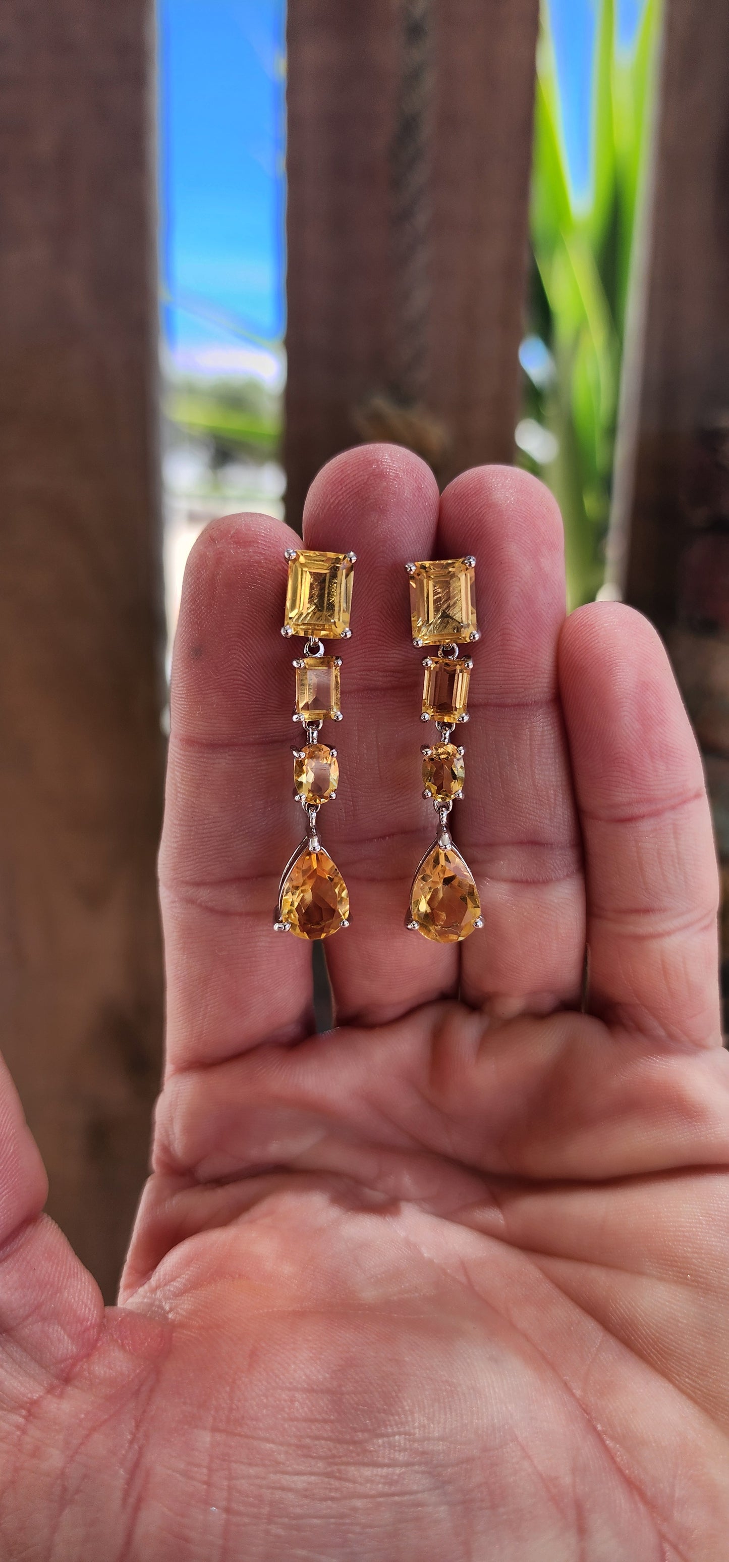 This exquisite pair of sterling silver drop earrings is a masterpiece of design and craftsmanship. Each earring is adorned with a carefully curated arrangement of radiant citrine gemstones, creating a cascade of light and warmth.