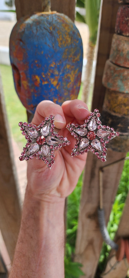 These are fabulous handmade star shaped dress clips that are equal parts dramatic and versatile. Each clip is designed in a bold starburst pattern, featuring a dazzling mix of pink glass rhinestones.