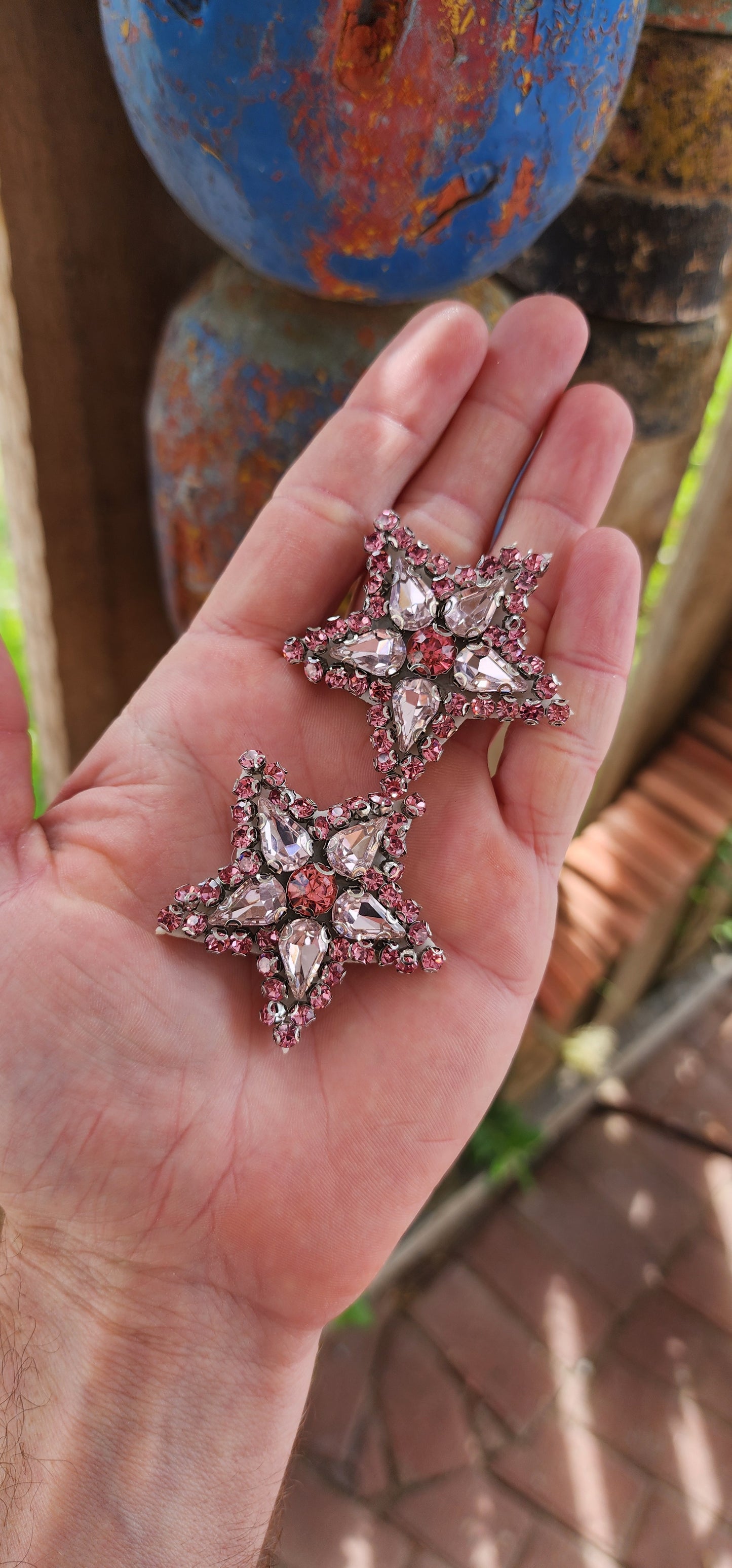 These are fabulous handmade star shaped dress clips that are equal parts dramatic and versatile. Each clip is designed in a bold starburst pattern, featuring a dazzling mix of pink glass rhinestones.