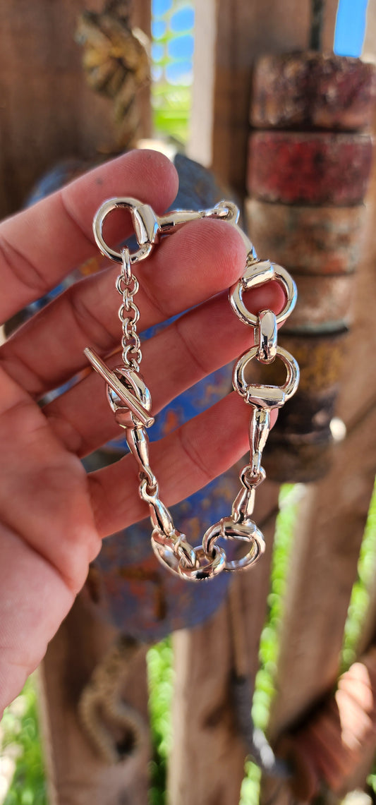 This bracelet is the ultimate showstopper for equestrian enthusiasts and lovers of bold, timeless jewelry. Crafted from chunky, weighty solid sterling silver, it features an intricate design inspired by horse snaffle bits.